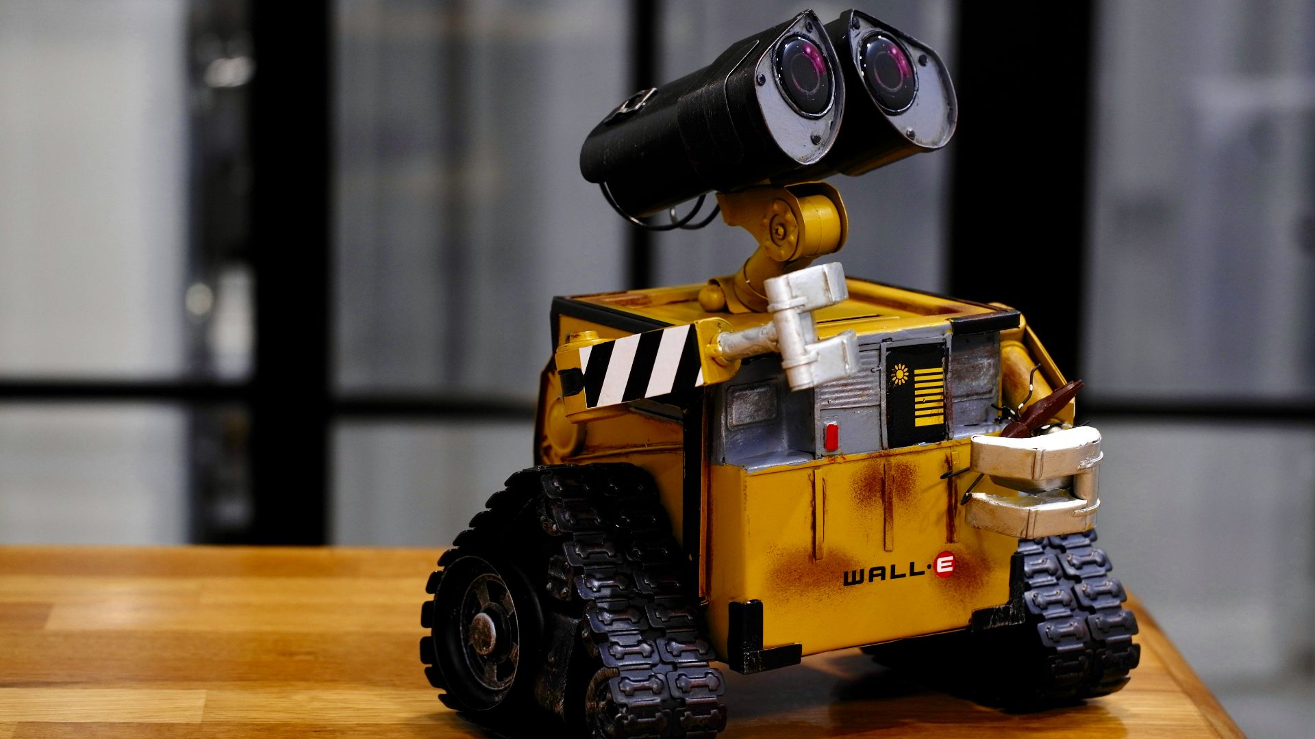 yellow and black Wall-E toy on brown wooden table