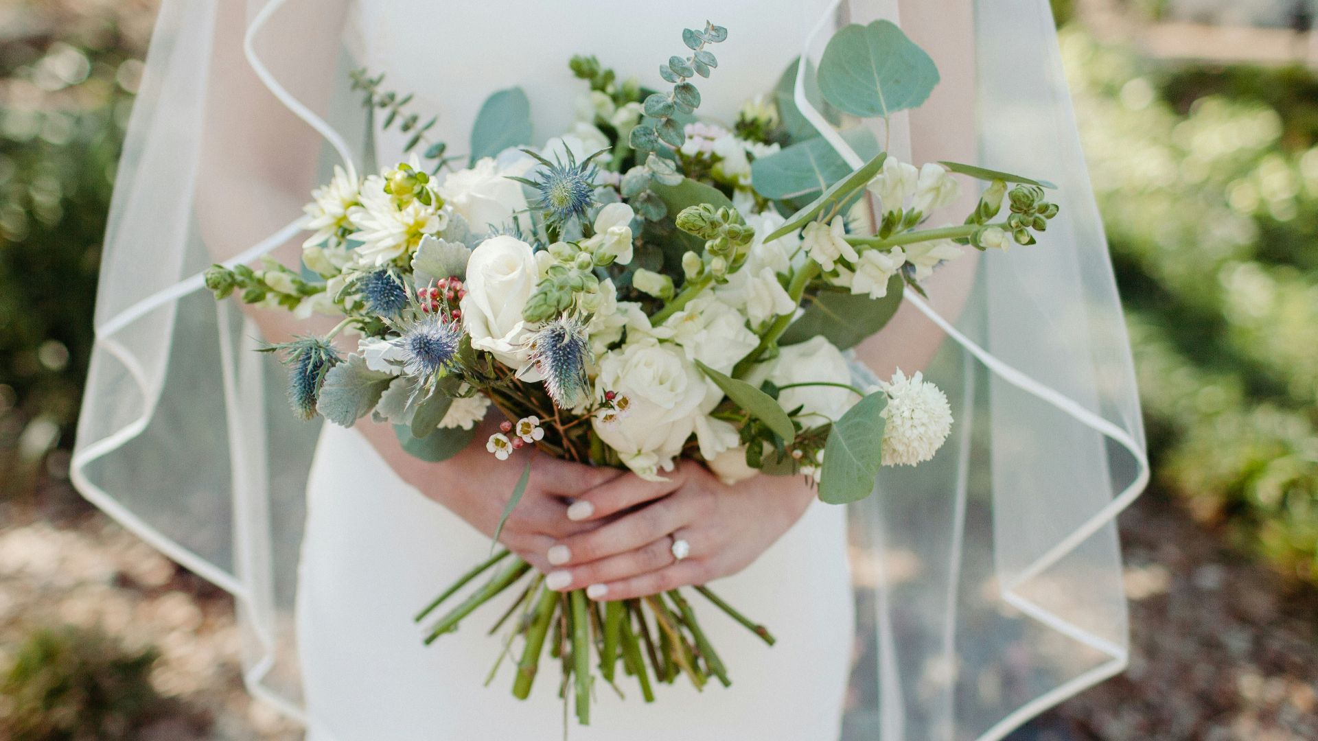 woman in white wedding dress holding white flower bouquet
