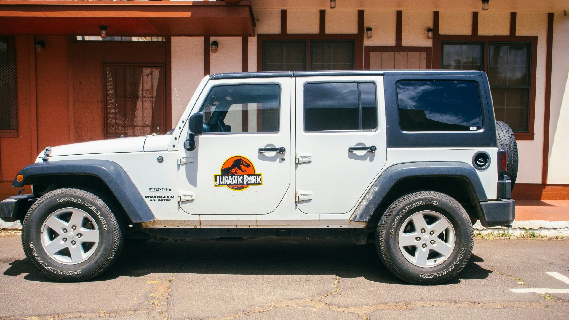 white vehicle parked near white and brown building