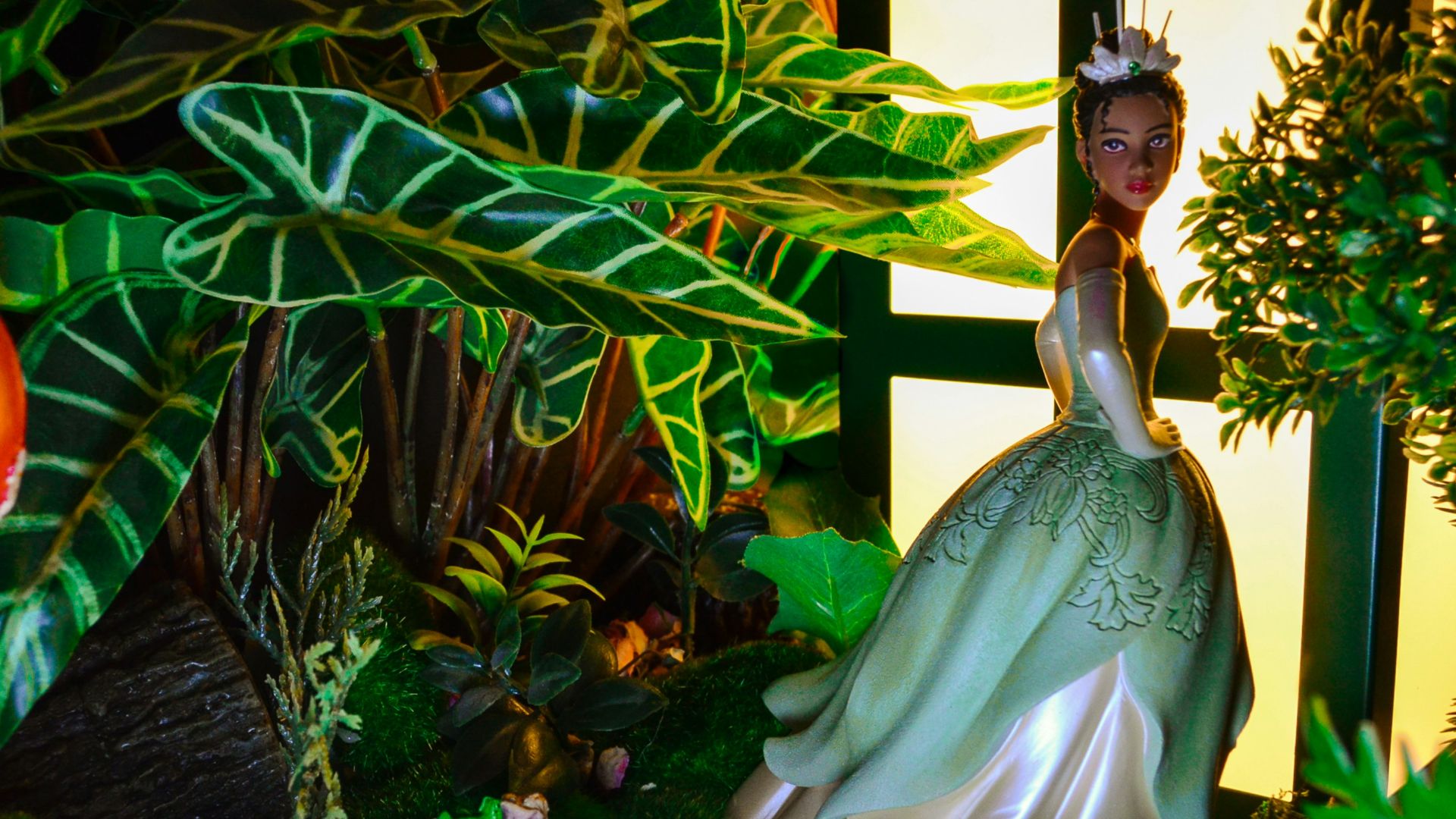 a statue of a woman in a green dress surrounded by plants