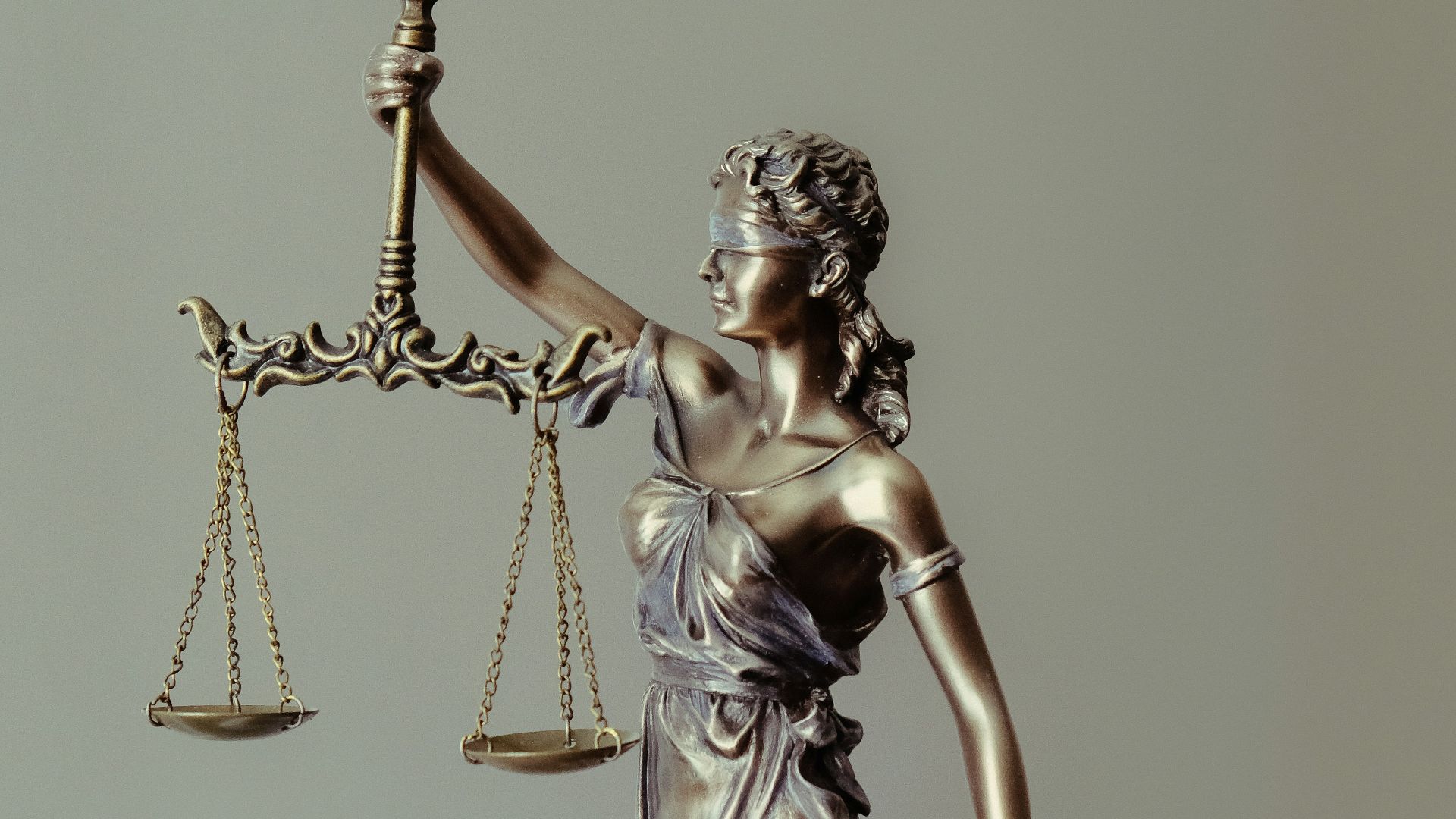 woman in gold dress holding sword figurine