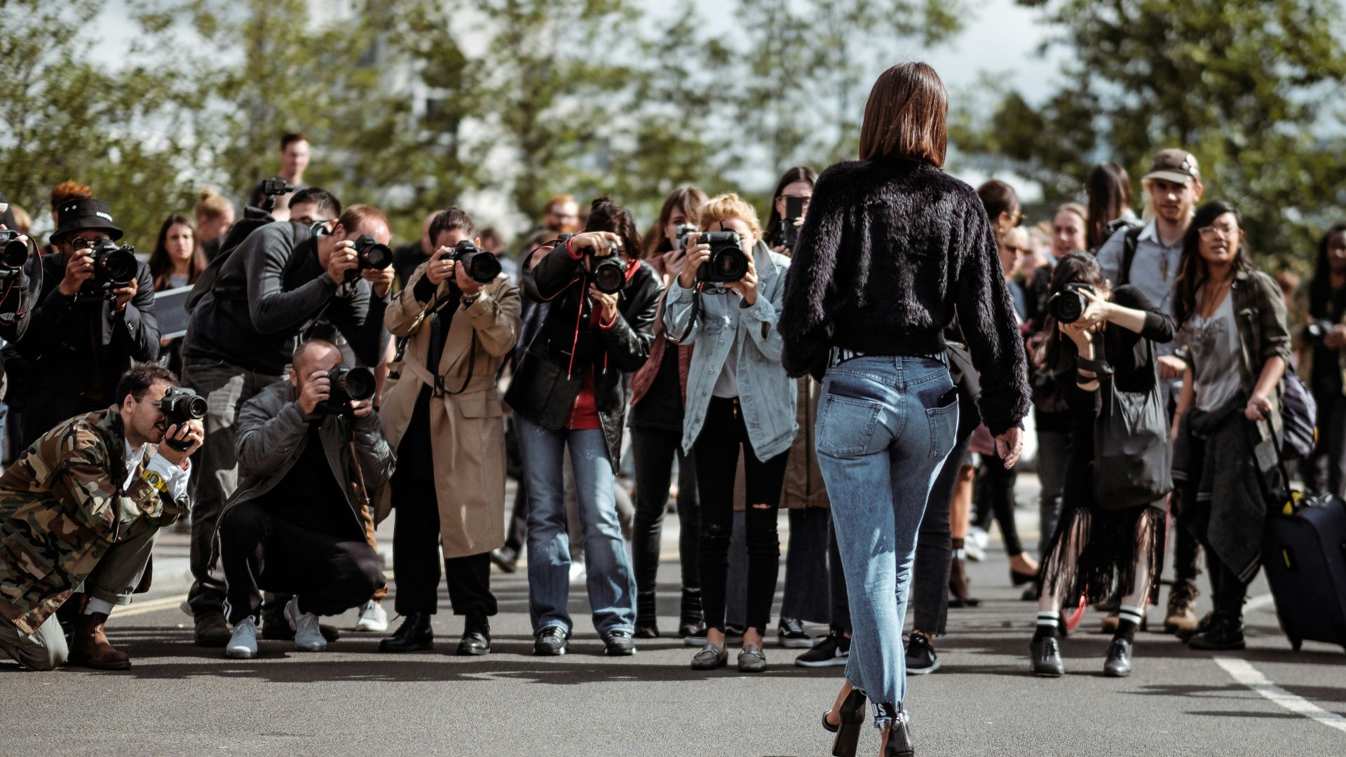 woman walking taking photo by people