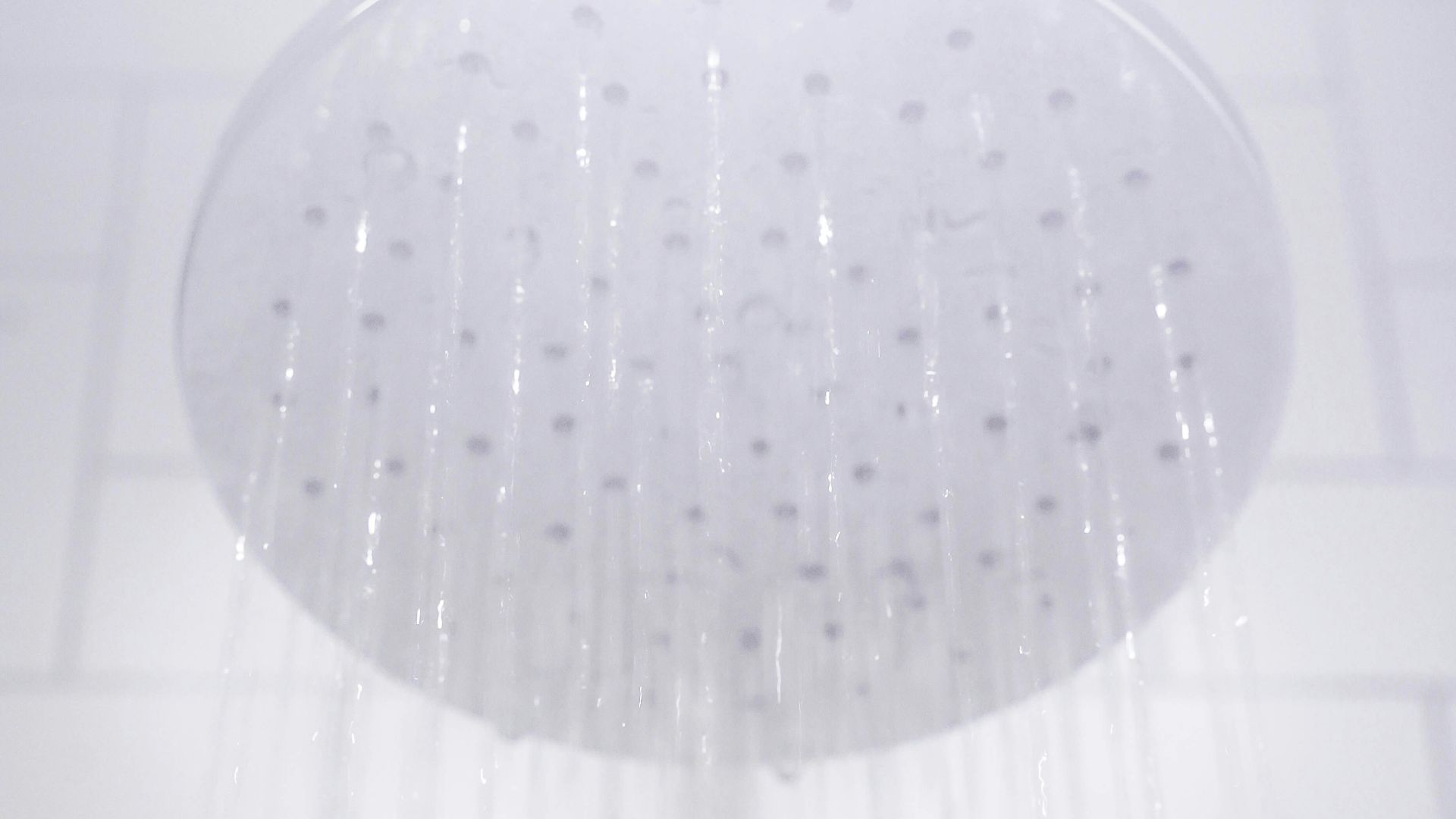 water from round gray stainless steel shower head