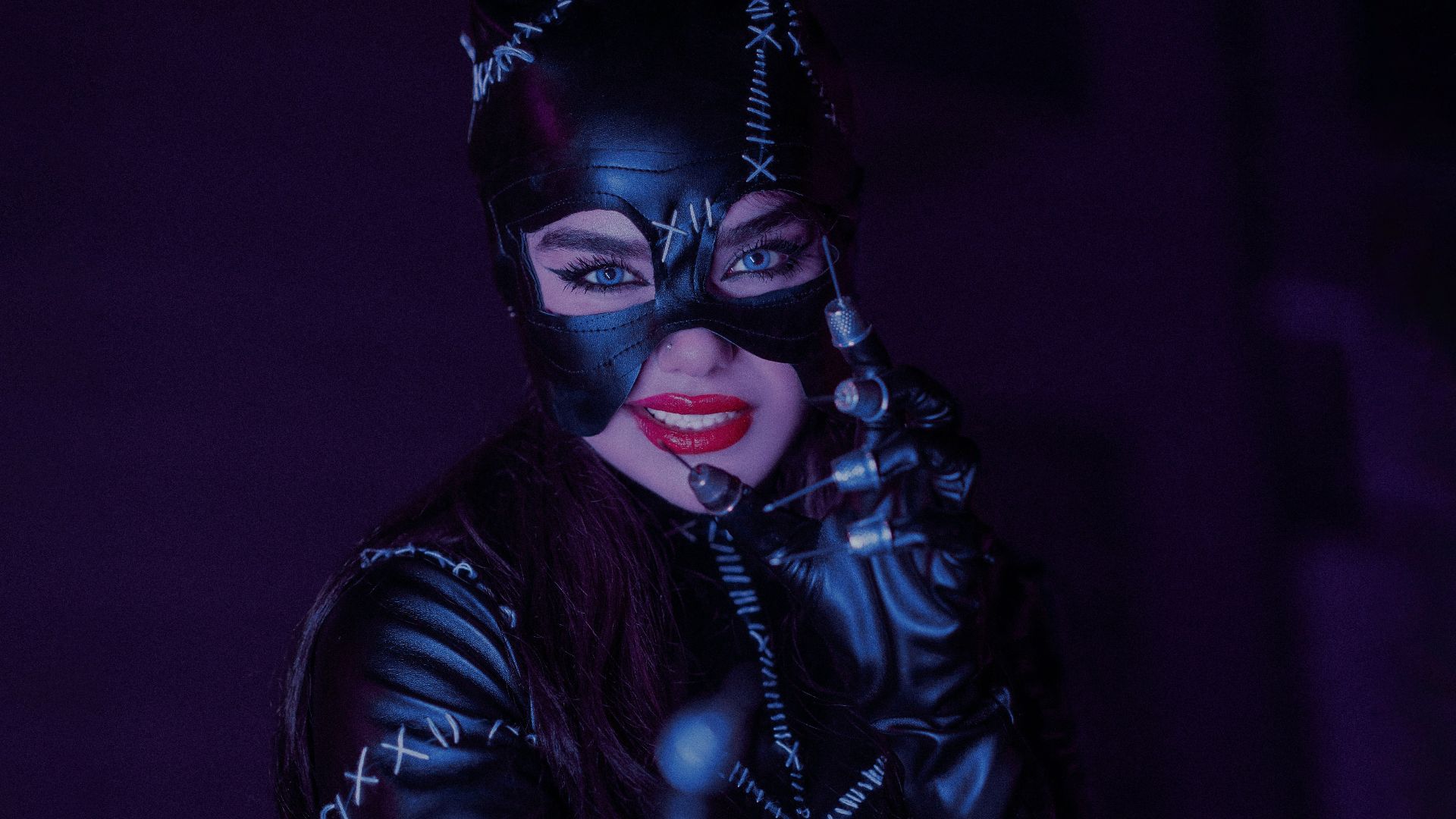 a woman dressed as a catwoman in a dark room