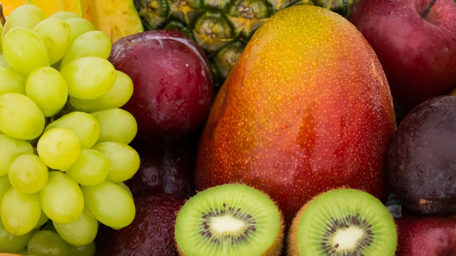red apple fruit beside green apple and yellow fruit on brown woven basket