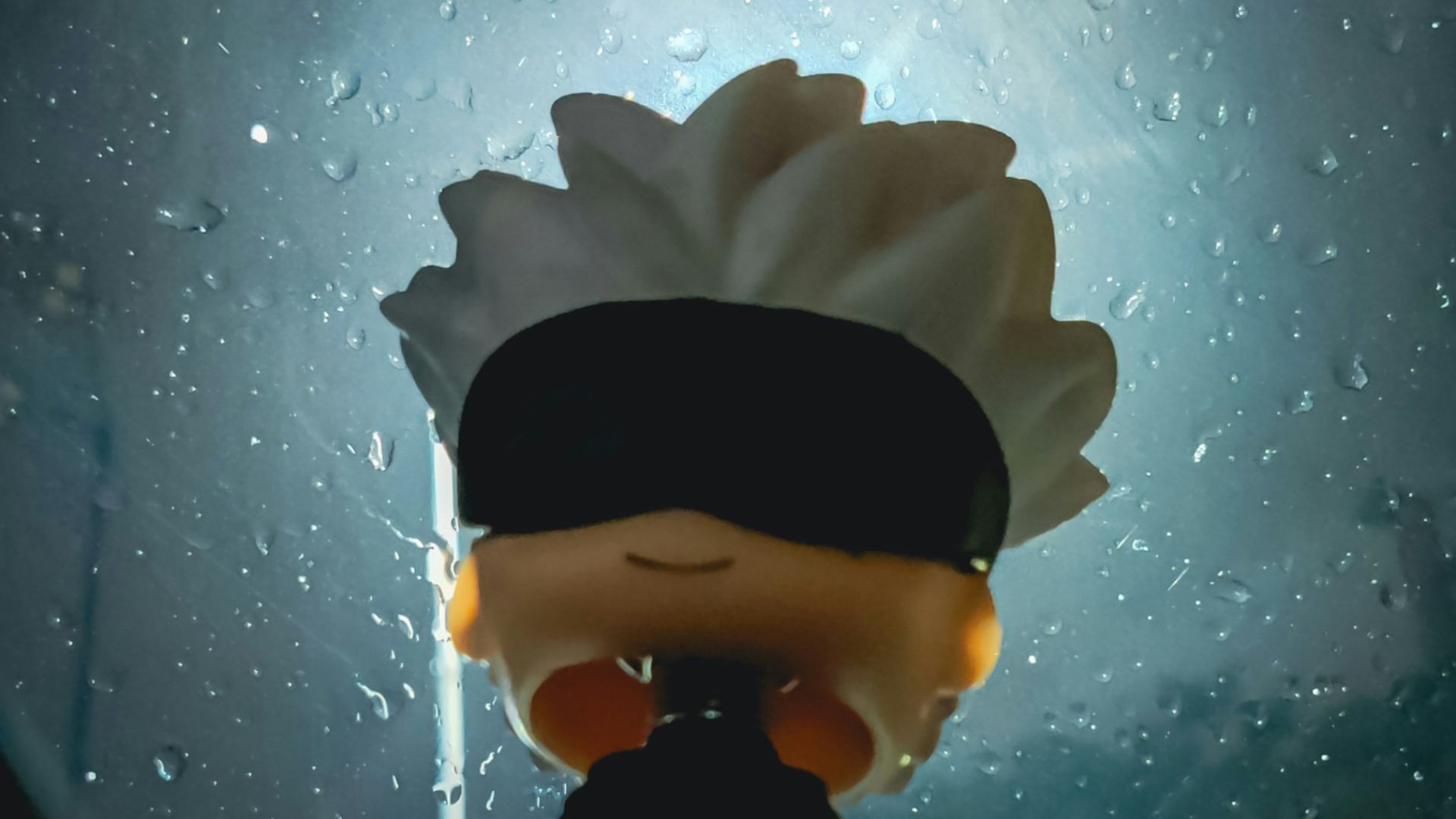 A person with a blindfolded head standing in front of a window