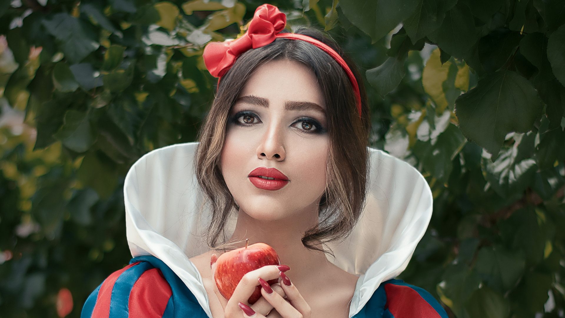 woman in red and white crew neck t-shirt holding red apple fruit