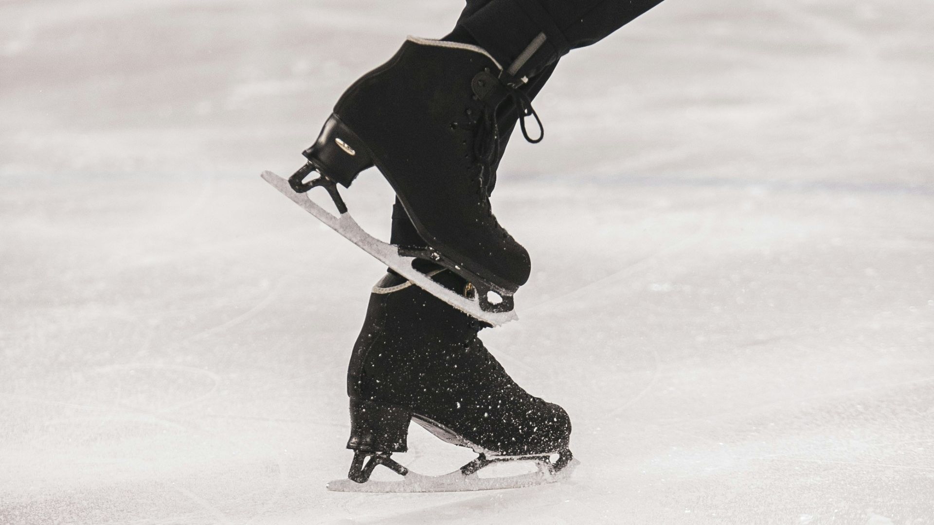 person in black jacket and black pants playing ice hockey