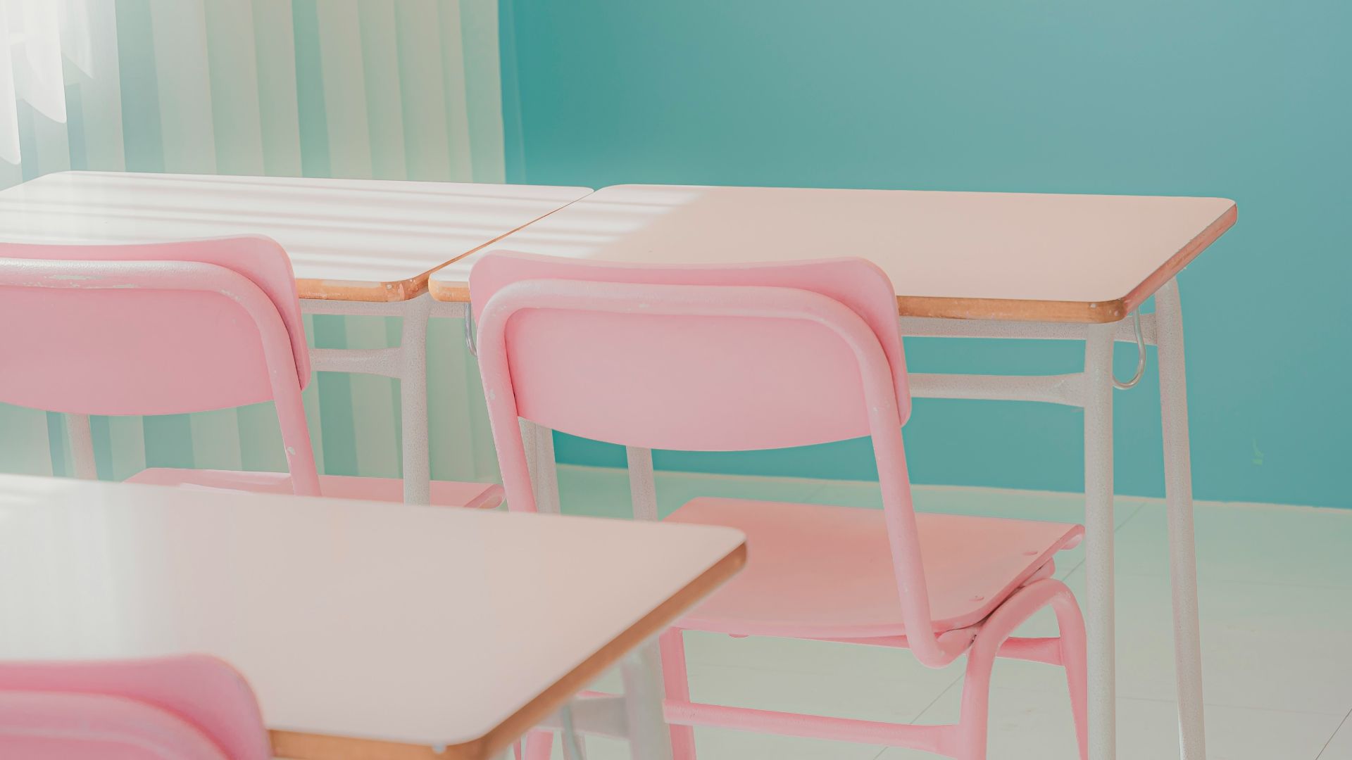 a row of pink chairs sitting next to a table