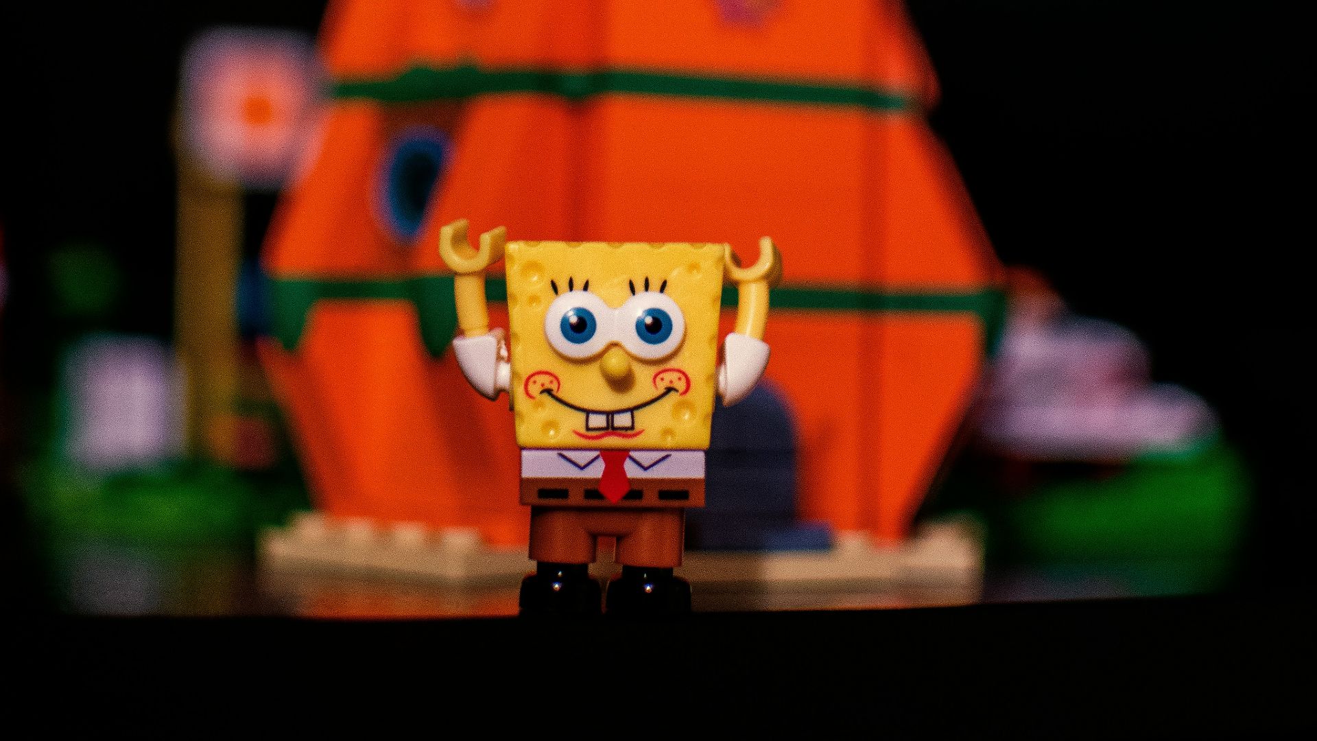 a toy spongebob is standing on a table