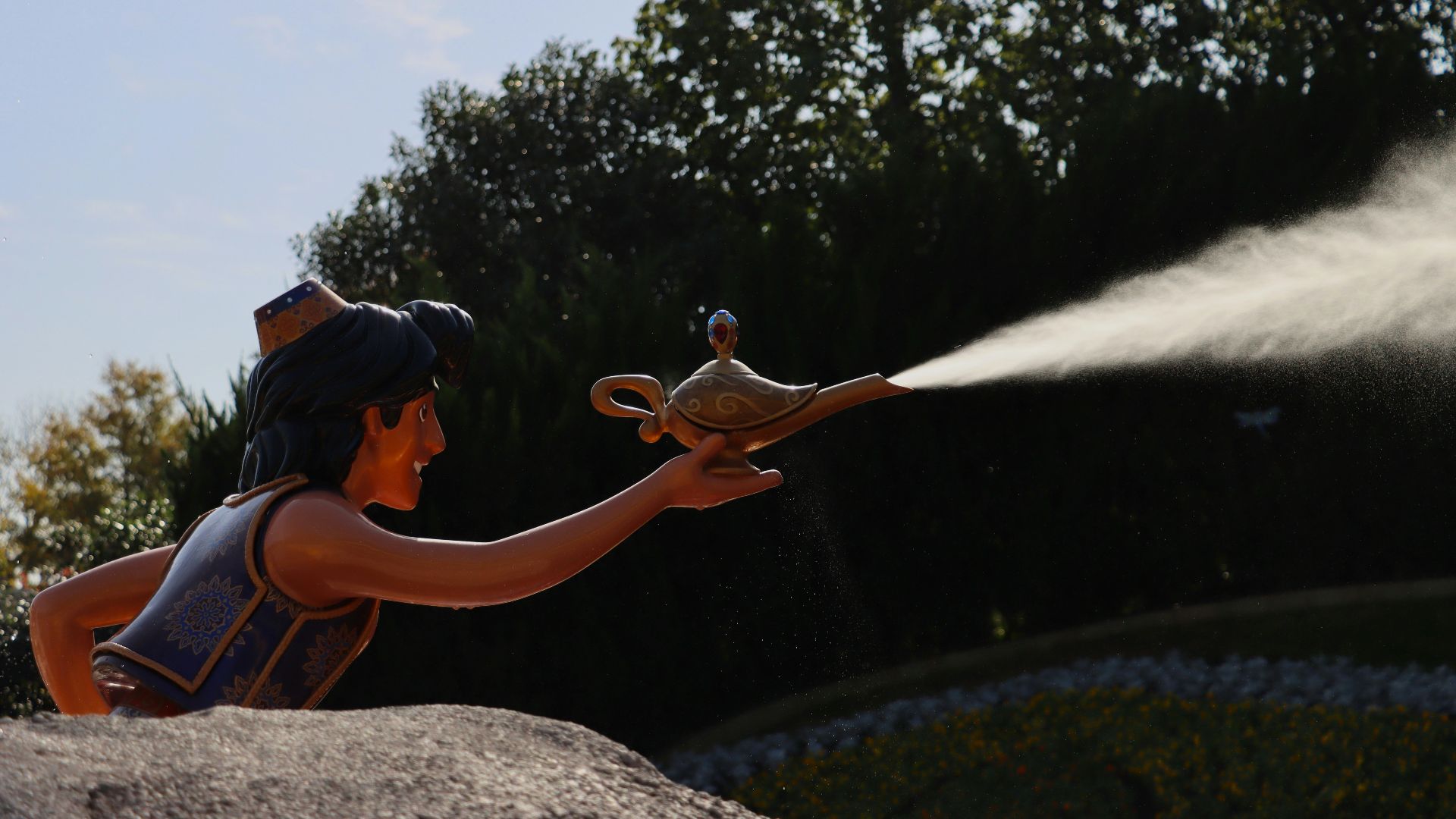 a statue of a person spraying water on a bird