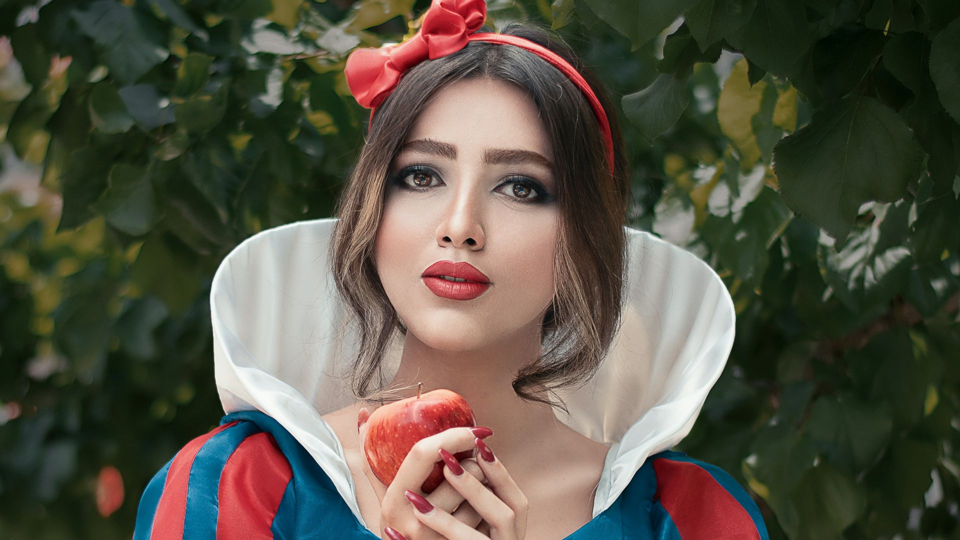 woman in red and white crew neck t-shirt holding red apple fruit