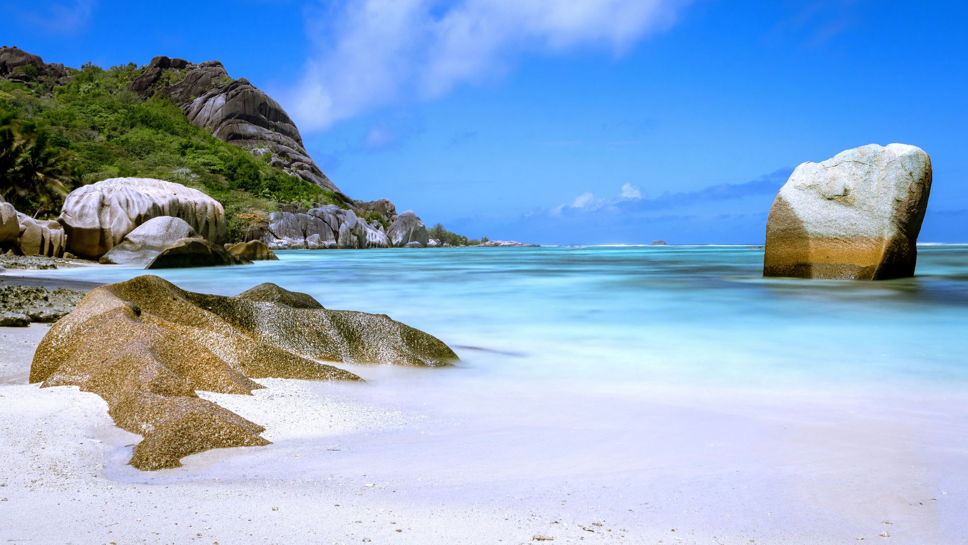 a large rock sitting on top of a sandy beach
