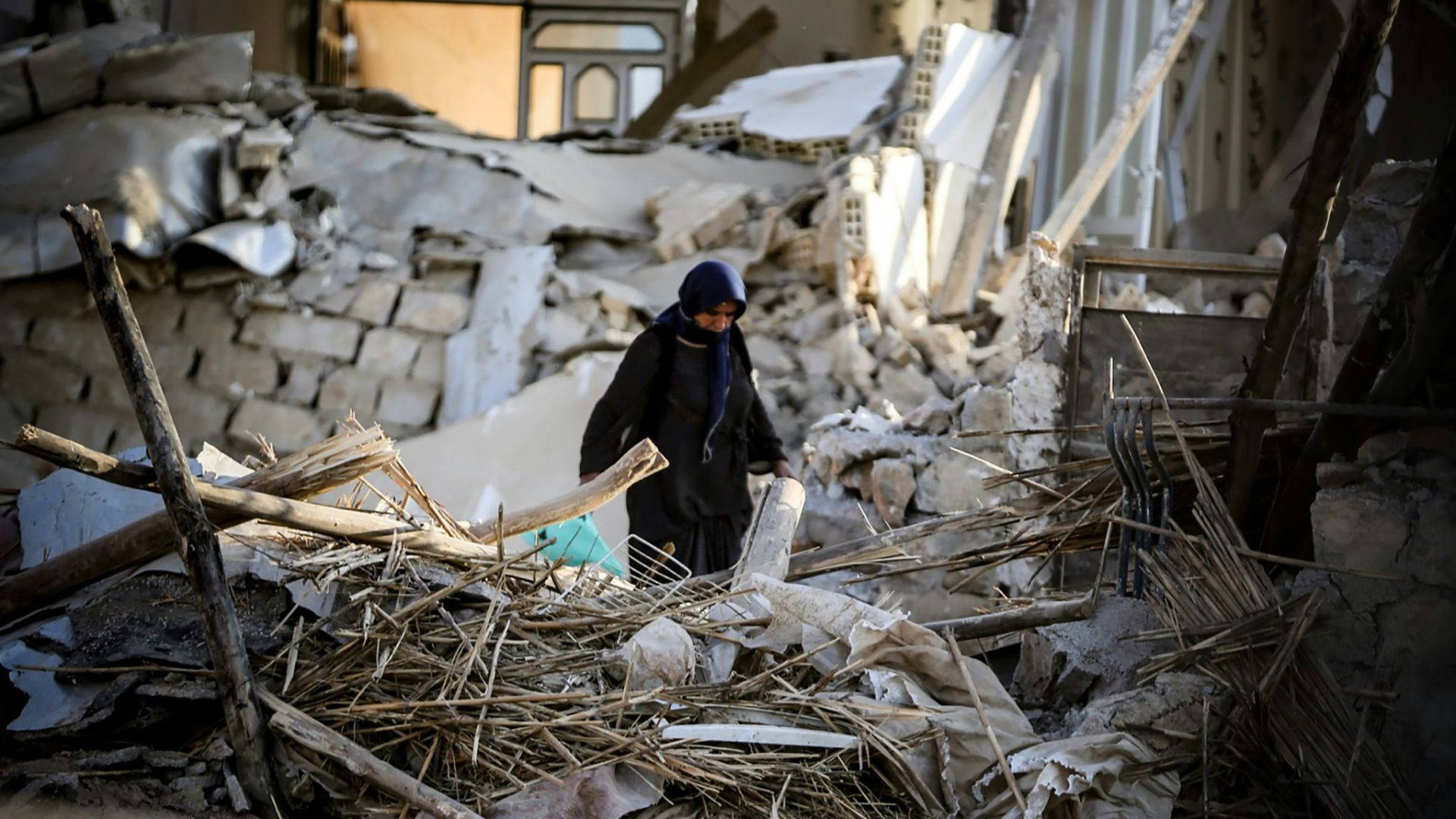 man in black jacket and black pants standing on brown wooden floor