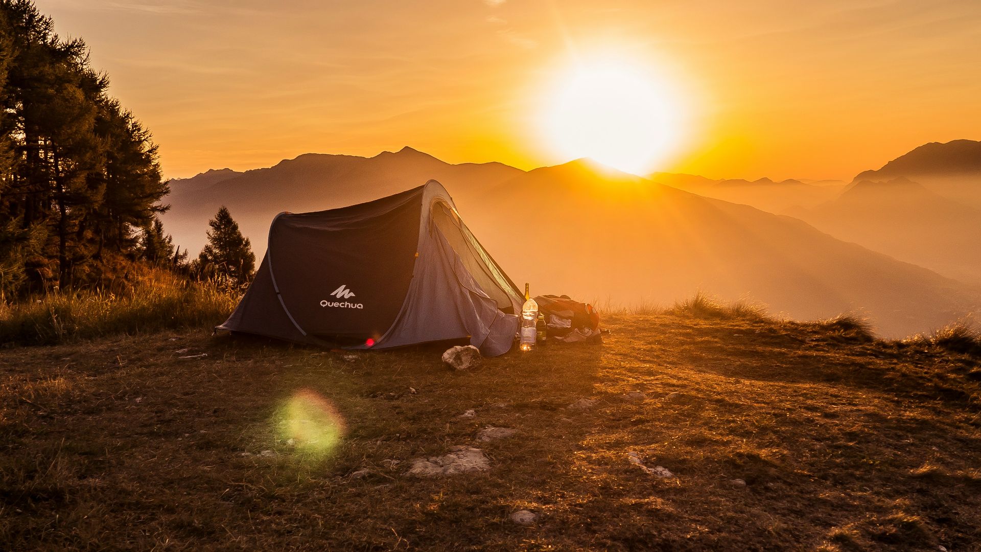 dome tent on mountain top with sun as background photo