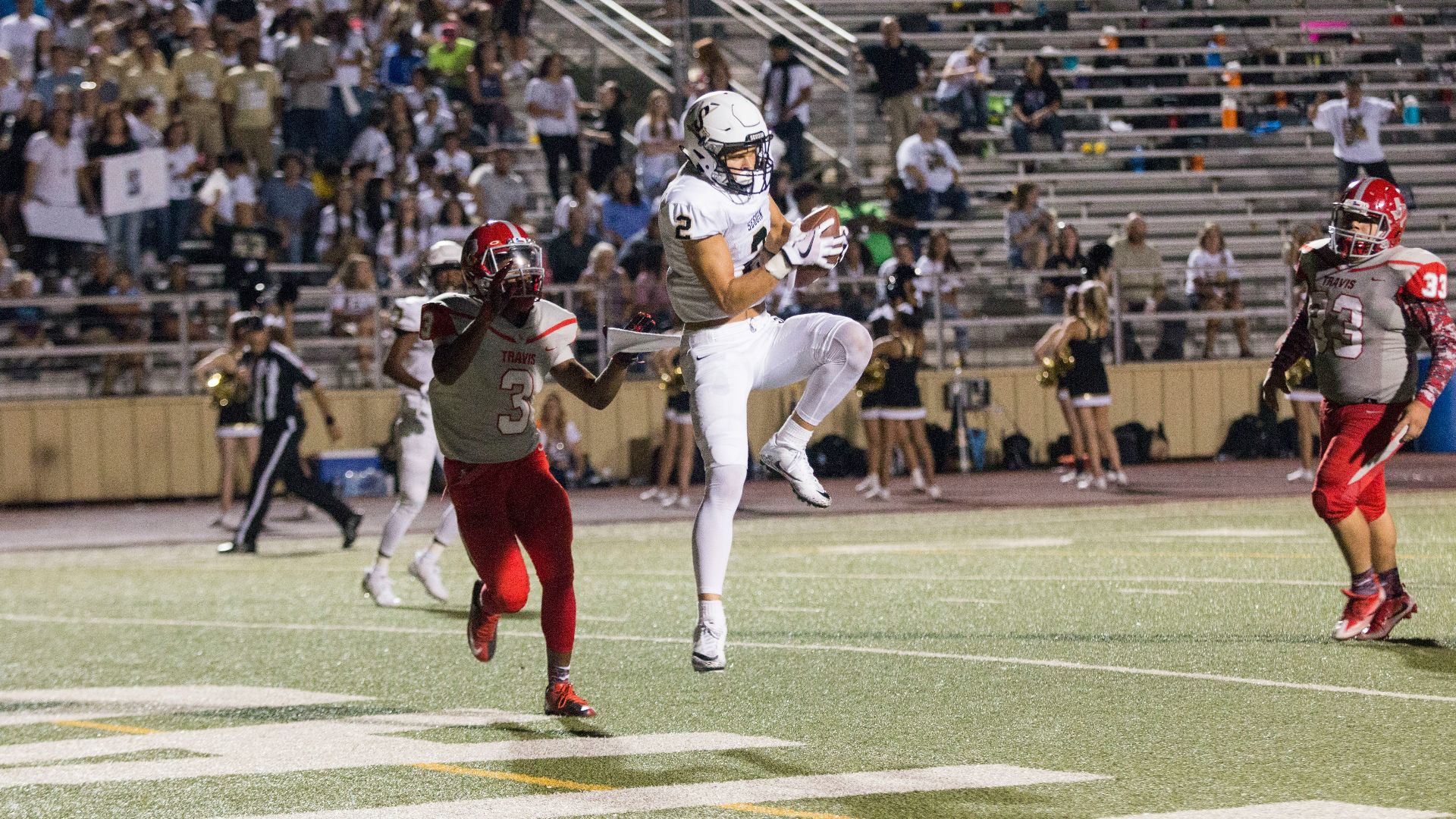 man catching brown football on stadium