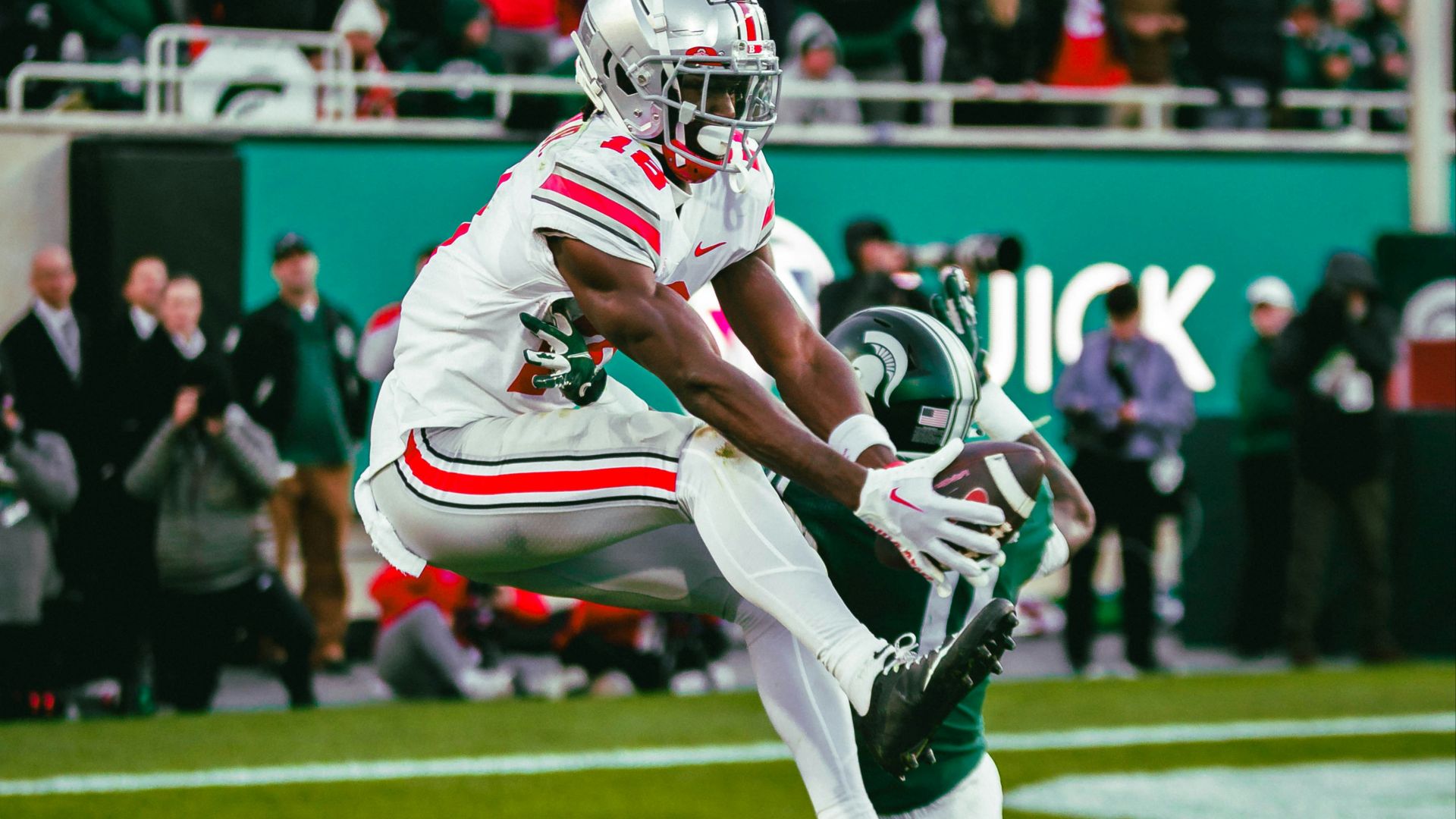 A football player running with a football on a field