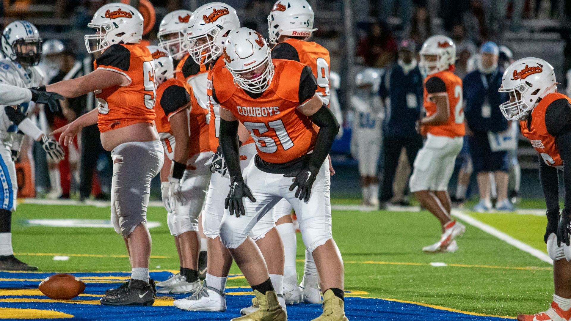 a group of football players standing on top of a field