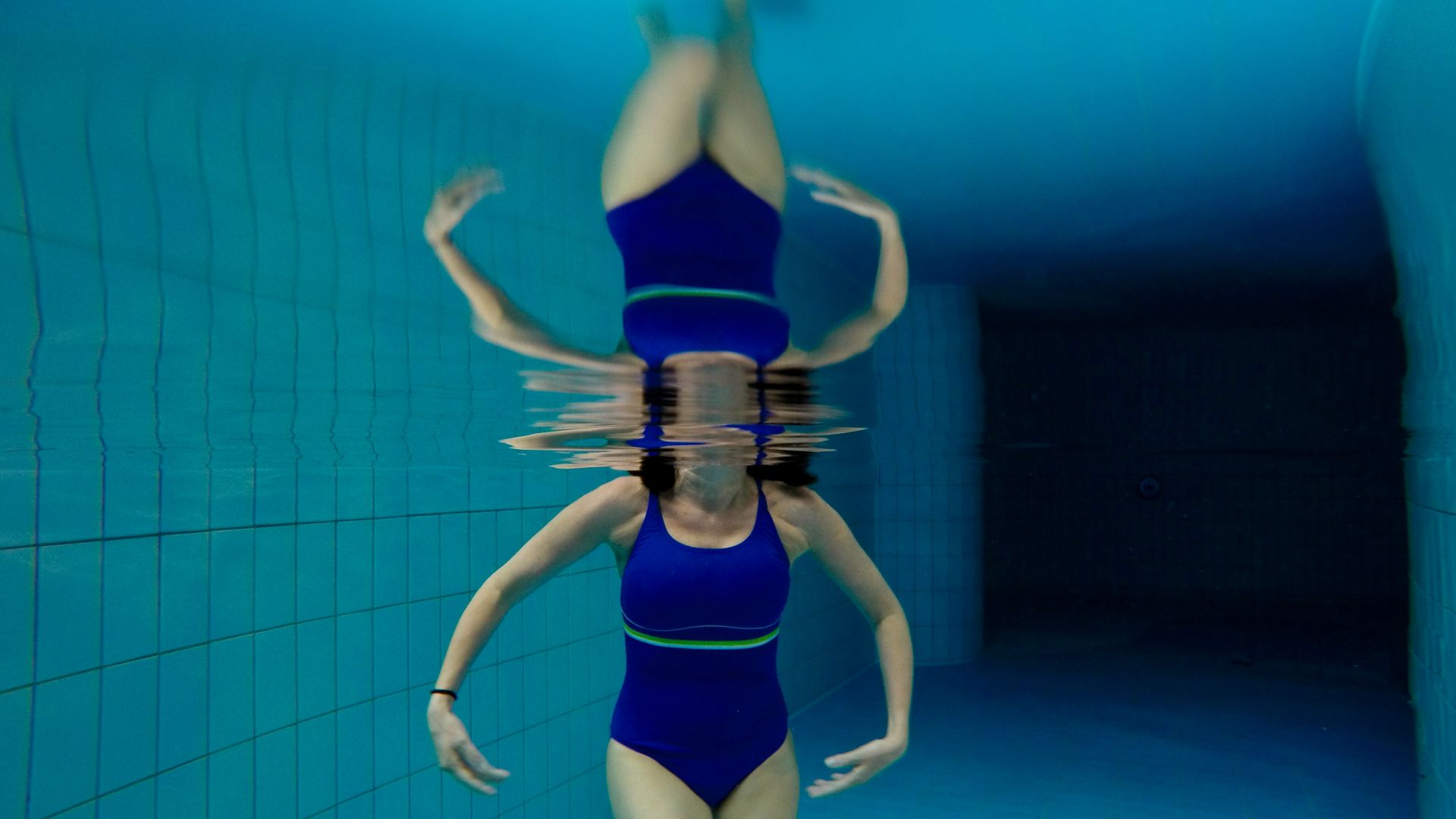 under water photography of woman wearing blue bodysuit