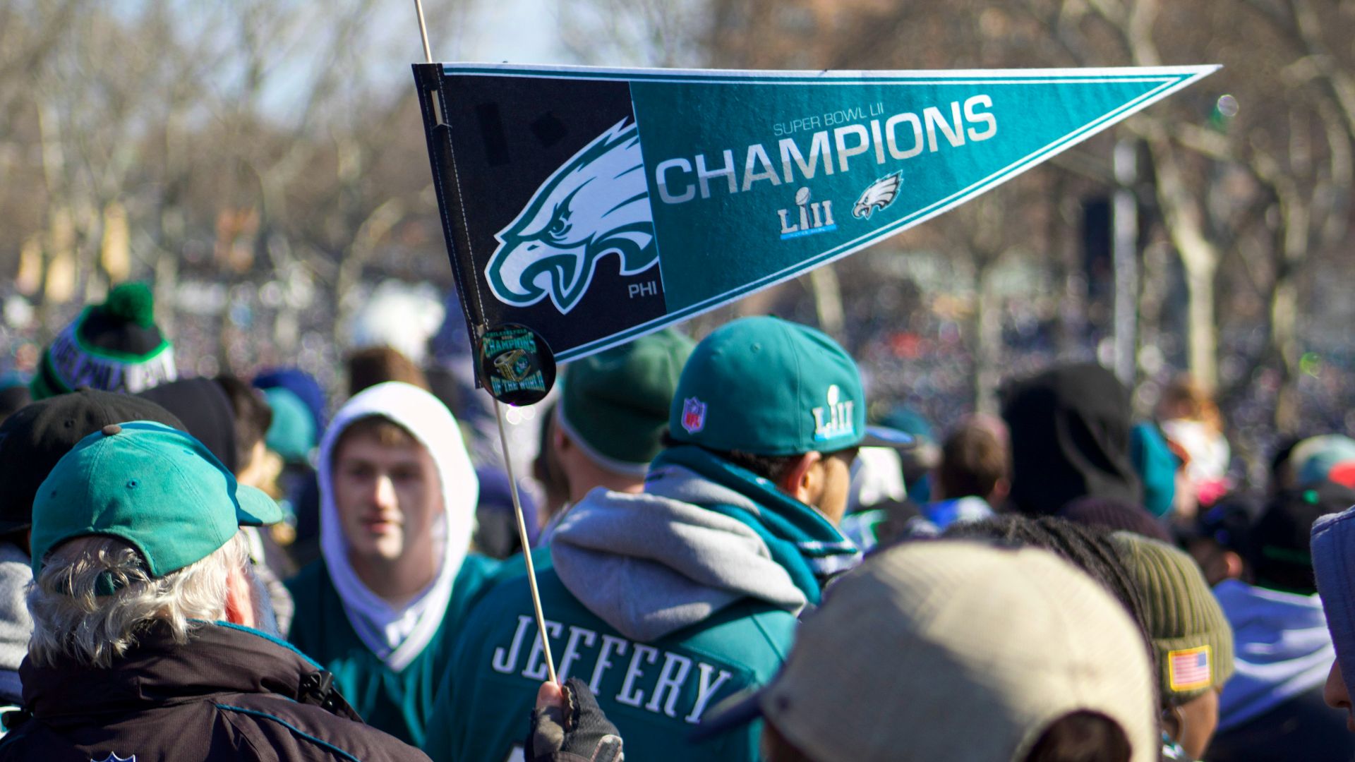 man holding Philadelphia Eagle pennant