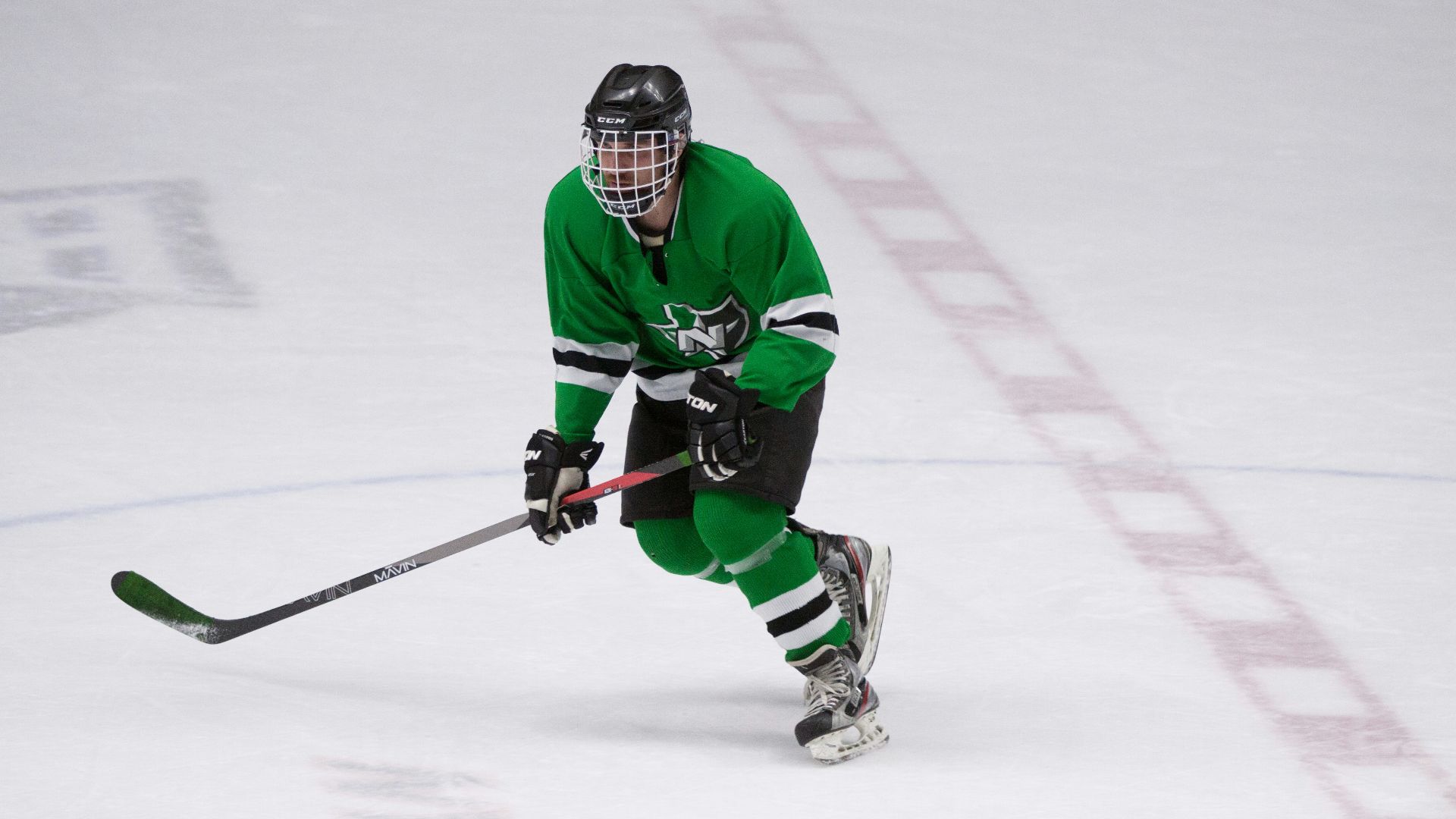 hockey player wearing full gear on ice skating field