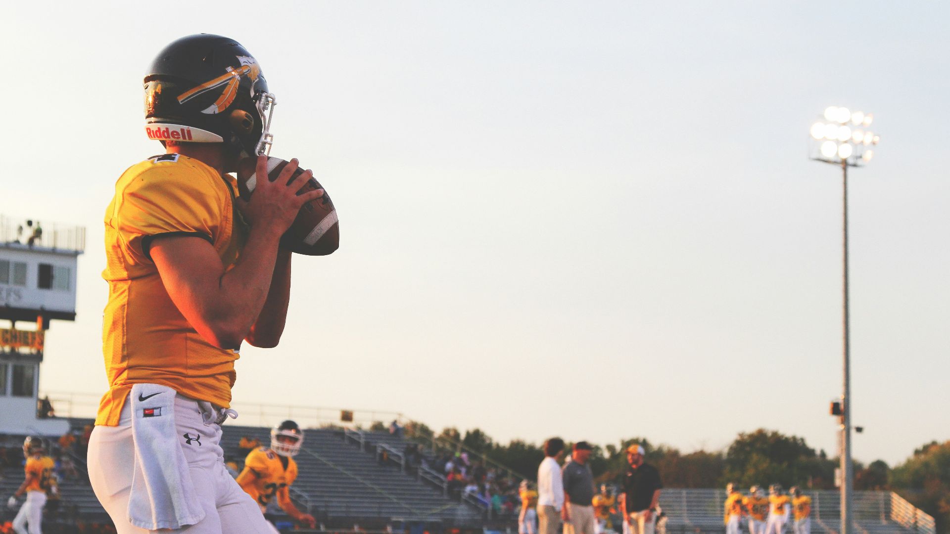 man holding brown football ball