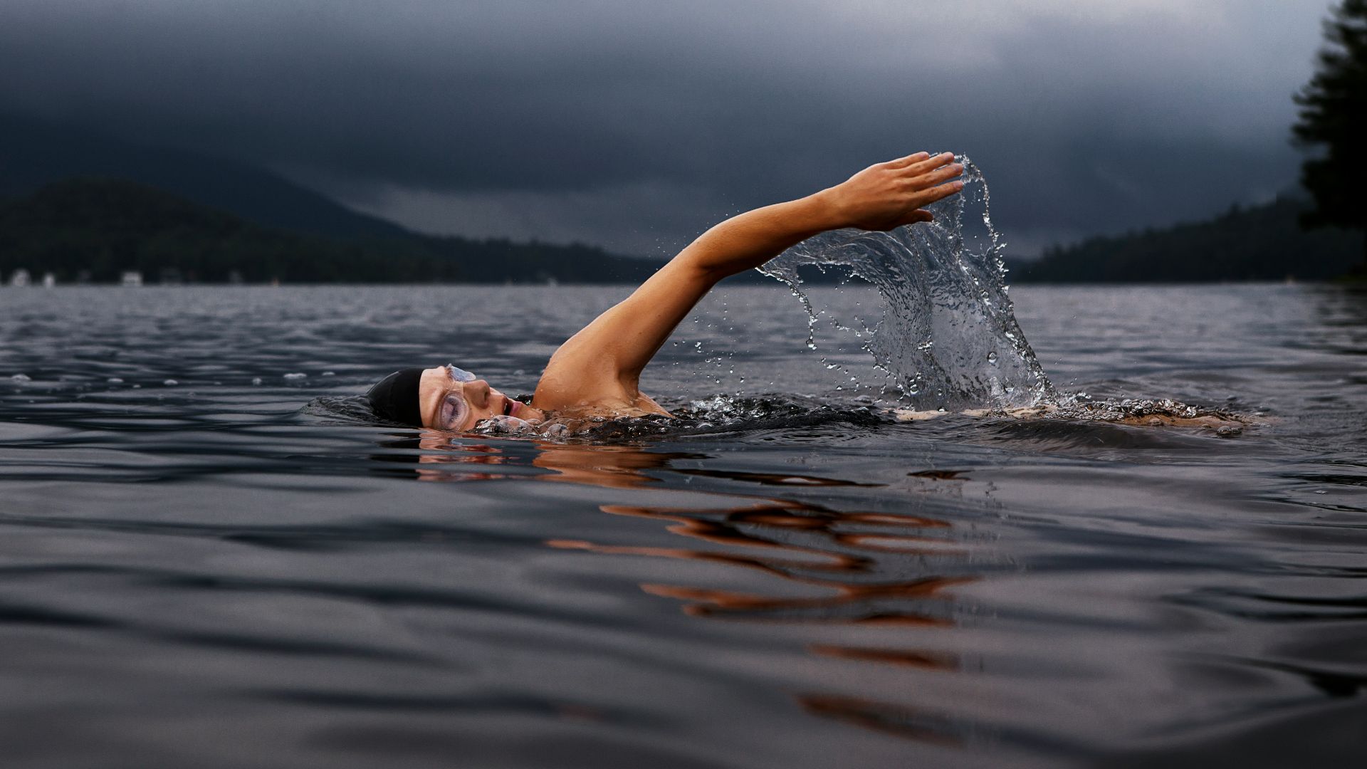 man swimming on body of water
