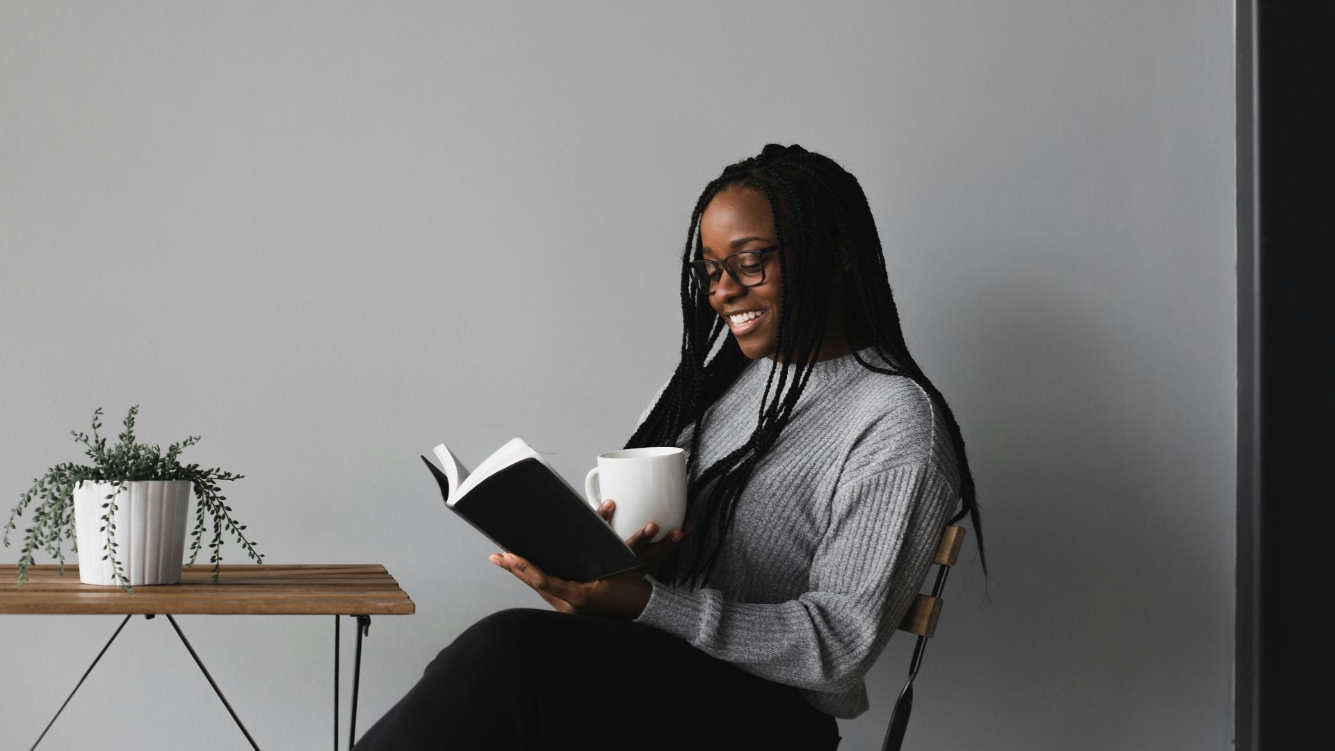 woman in white and black stripe long sleeve shirt sitting on chair