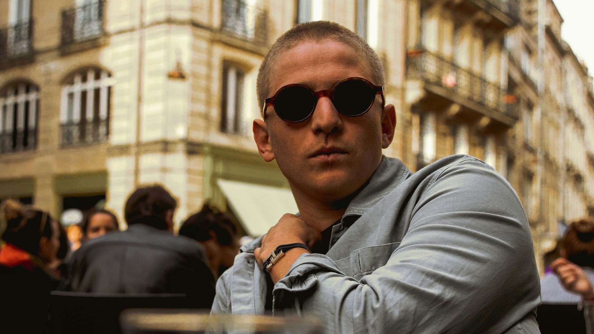 a man sitting at a table in front of a building