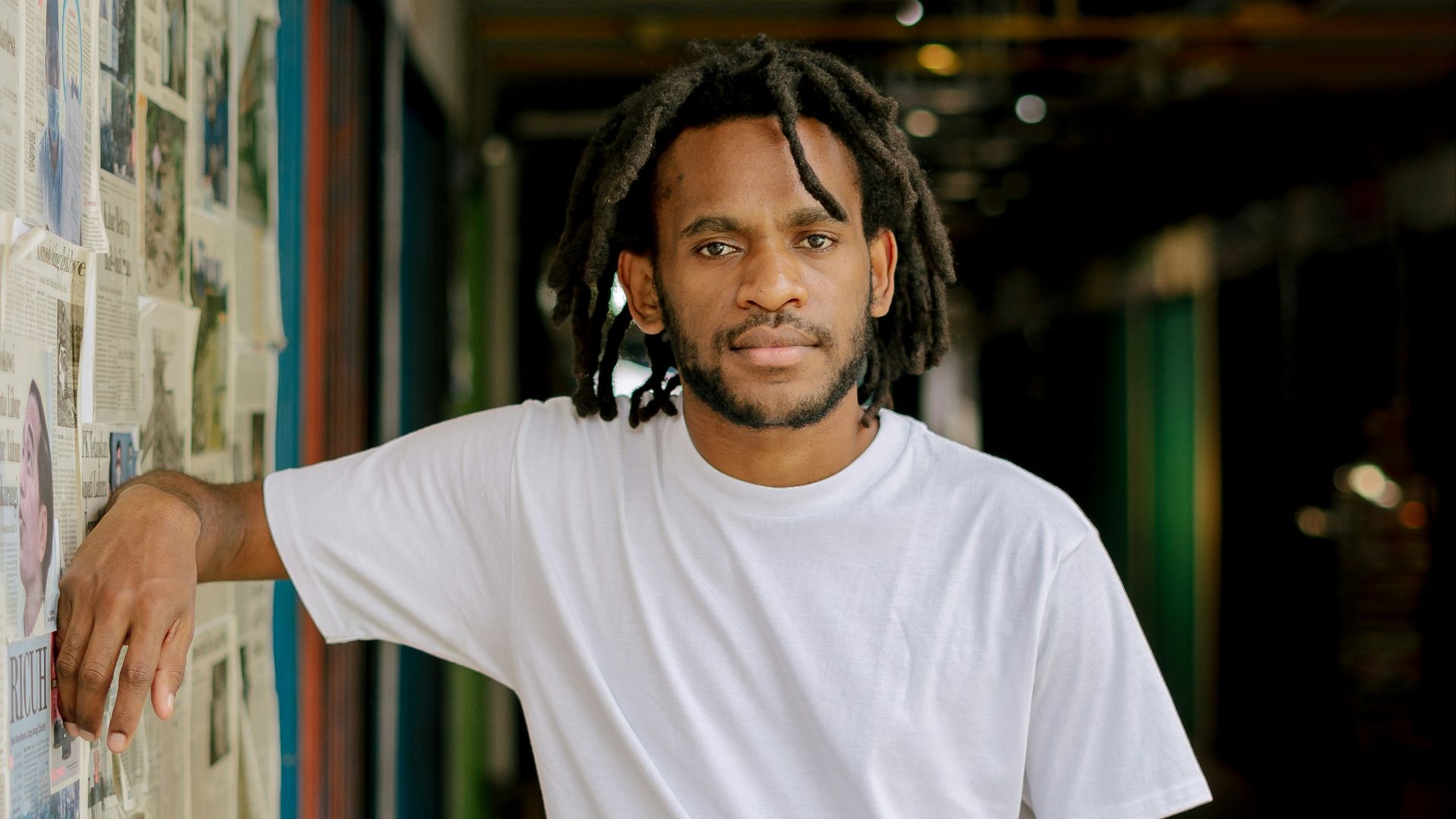 man in white crew neck t-shirt wearing black headphones
