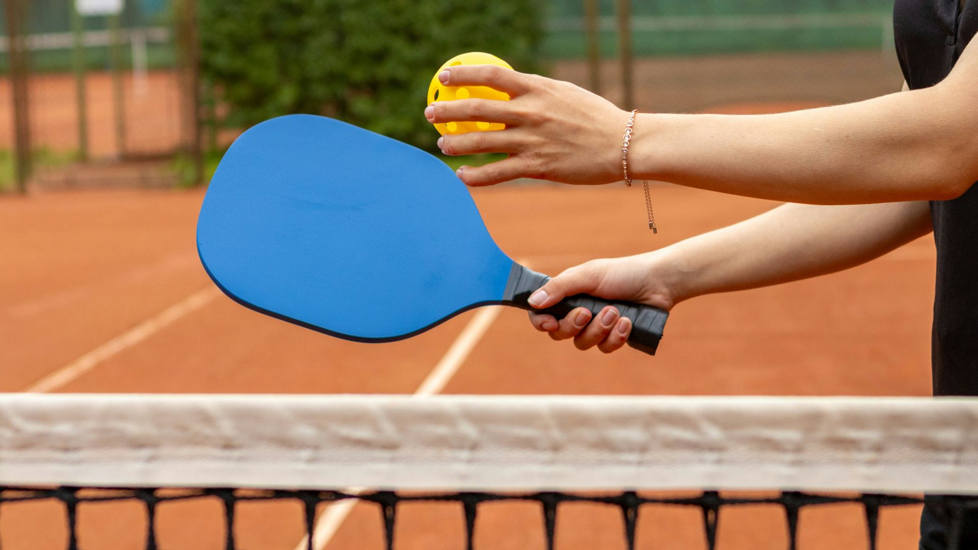 a person holding a tennis racket and a ball