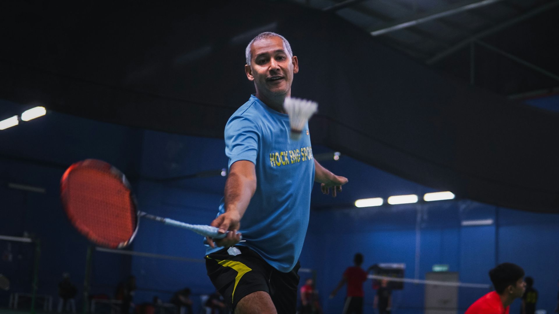 man in blue crew neck t-shirt and black shorts holding red basketball