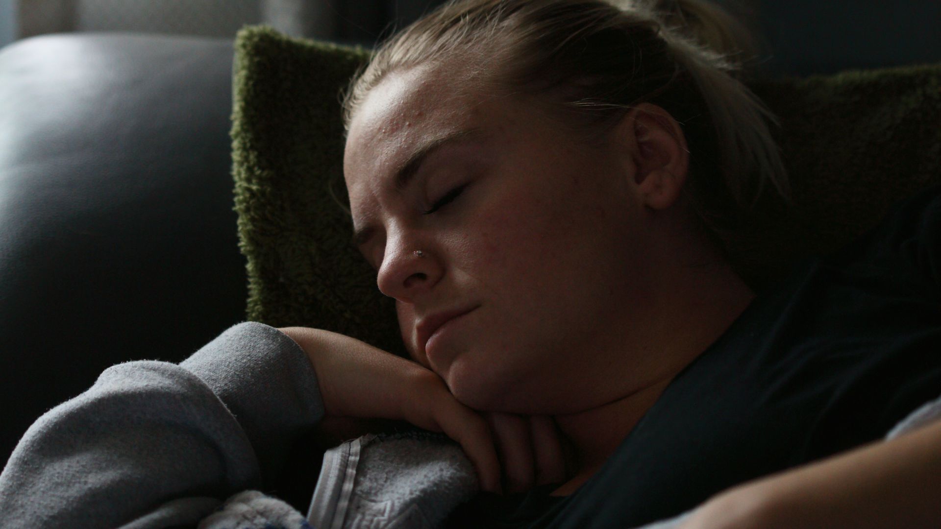 woman in black shirt lying on couch