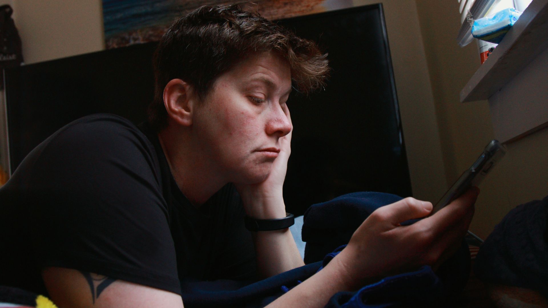 man in black crew neck t-shirt holding black smartphone