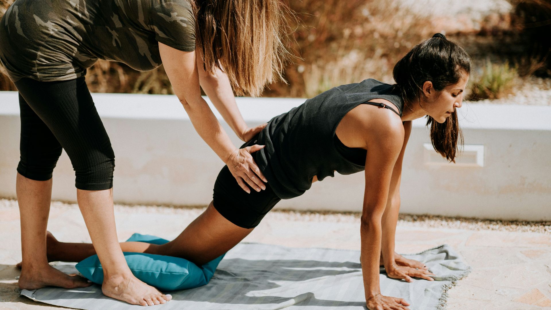 woman in black tank top and black shorts kneeling on mat