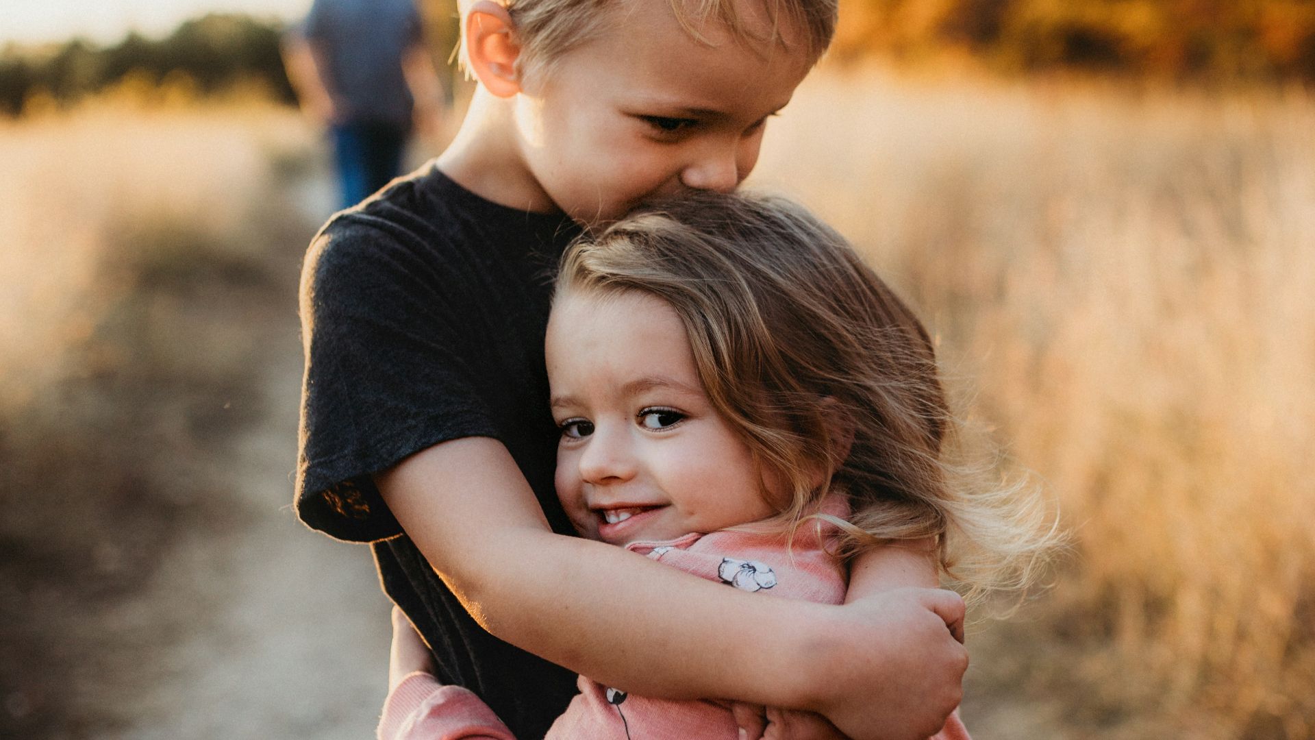 boy in black t-shirt hugging girl in red and white polka dot dress