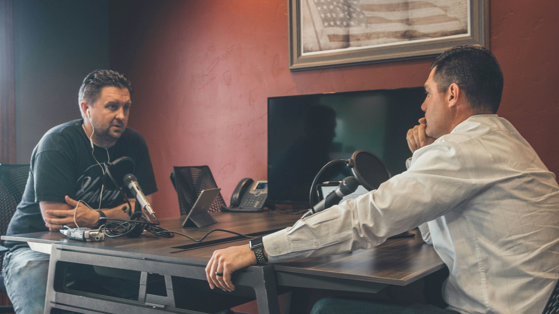 man sitting in front of another man also sitting inside room