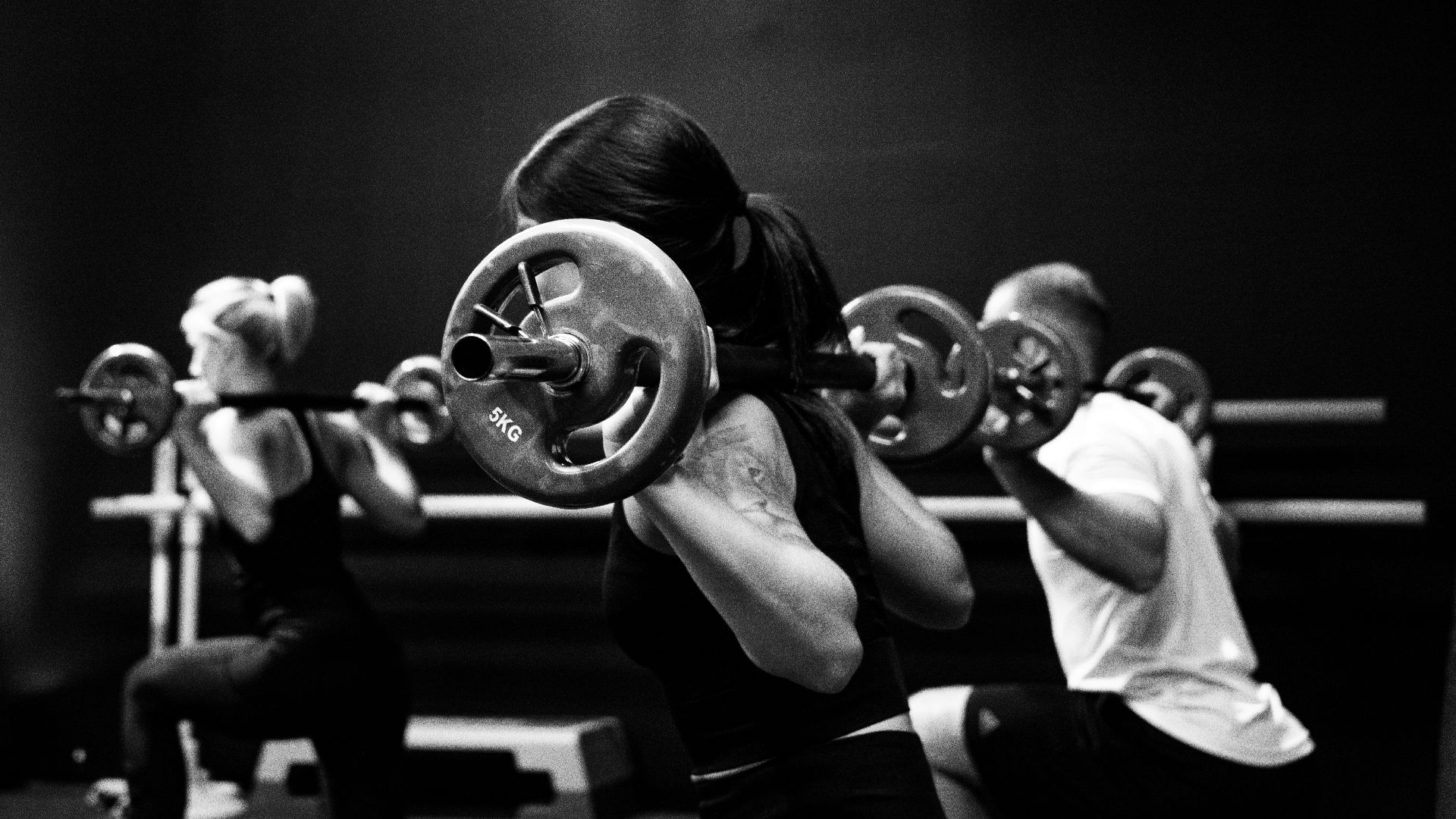 three person lifting barbels