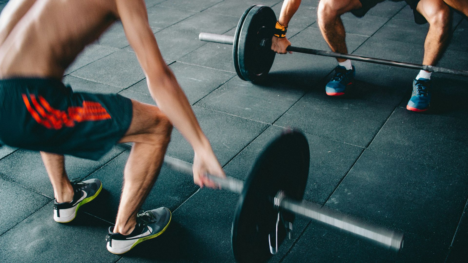 a man lifting a barbell in a gym