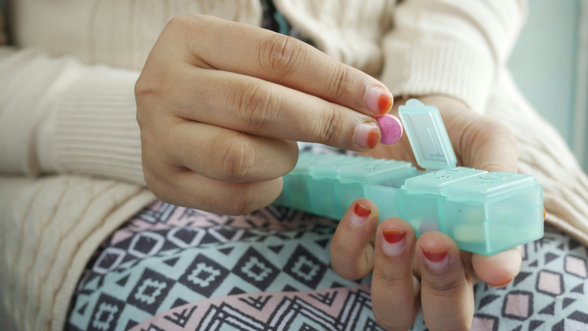 person holding white and green plastic container