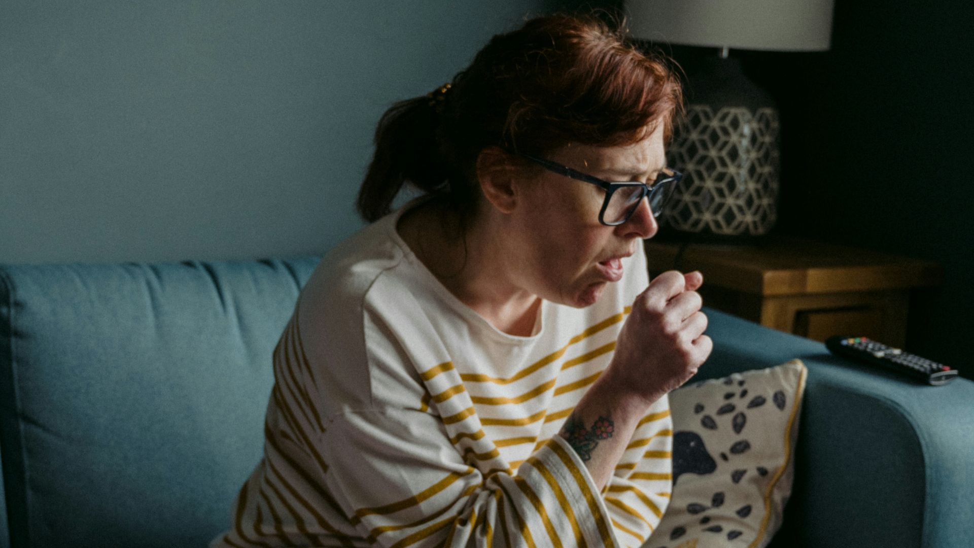 woman in white crew neck t-shirt sitting on gray sofa