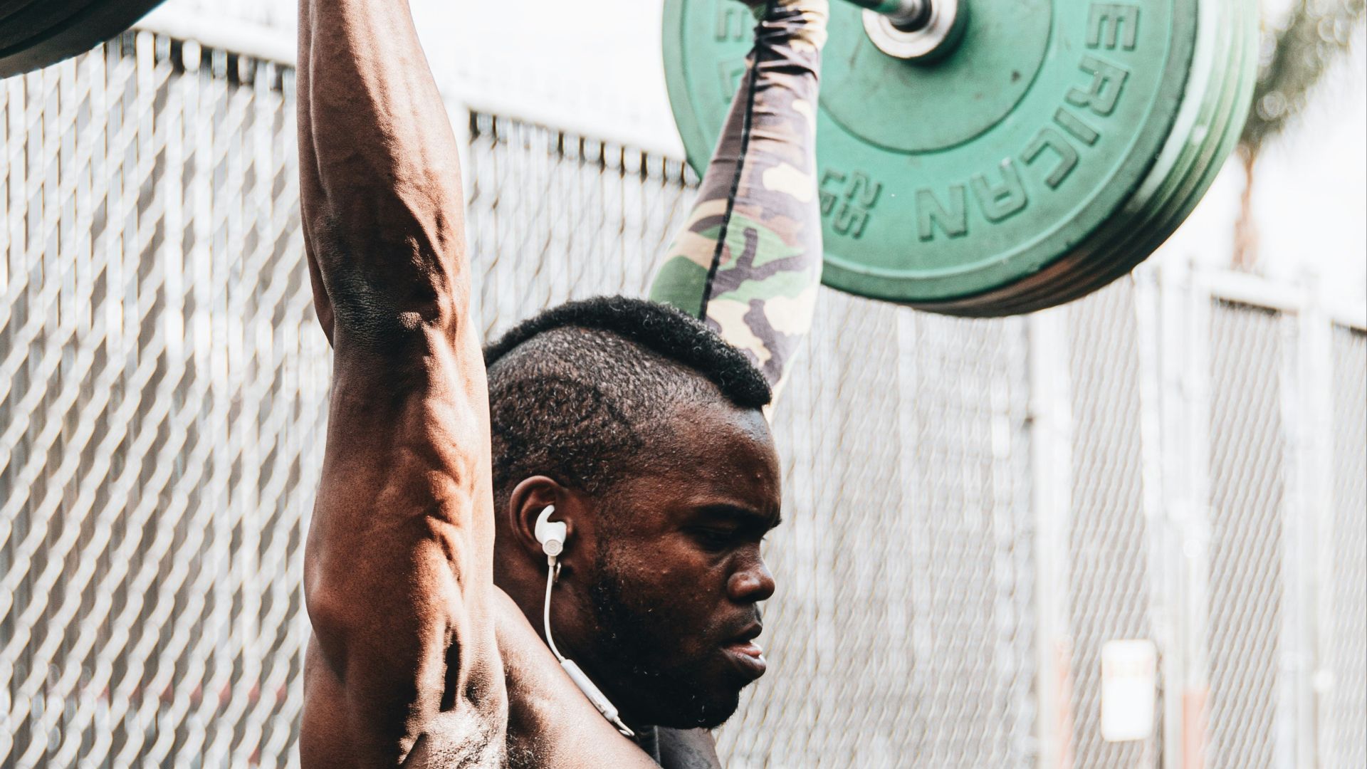 topless man holding green dumbbell