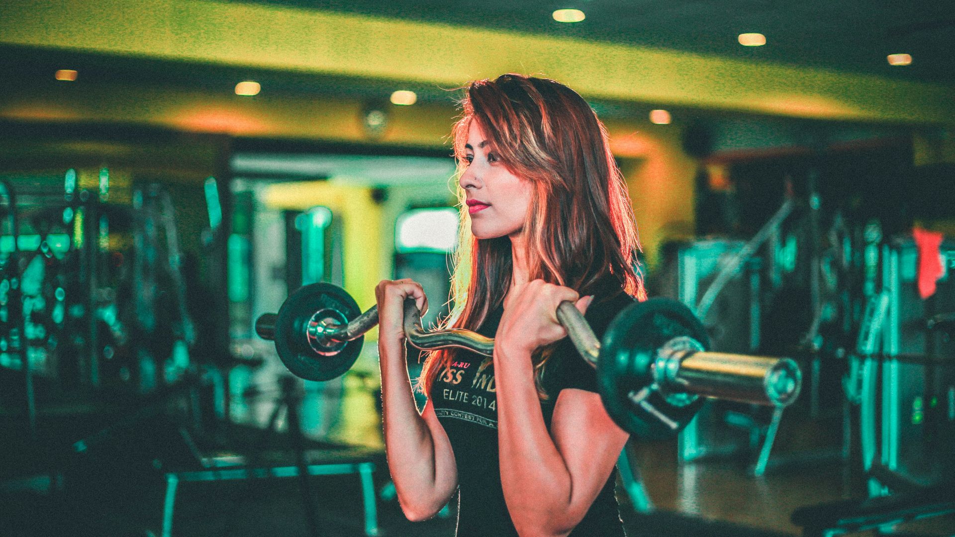woman lifting black and gray barbell
