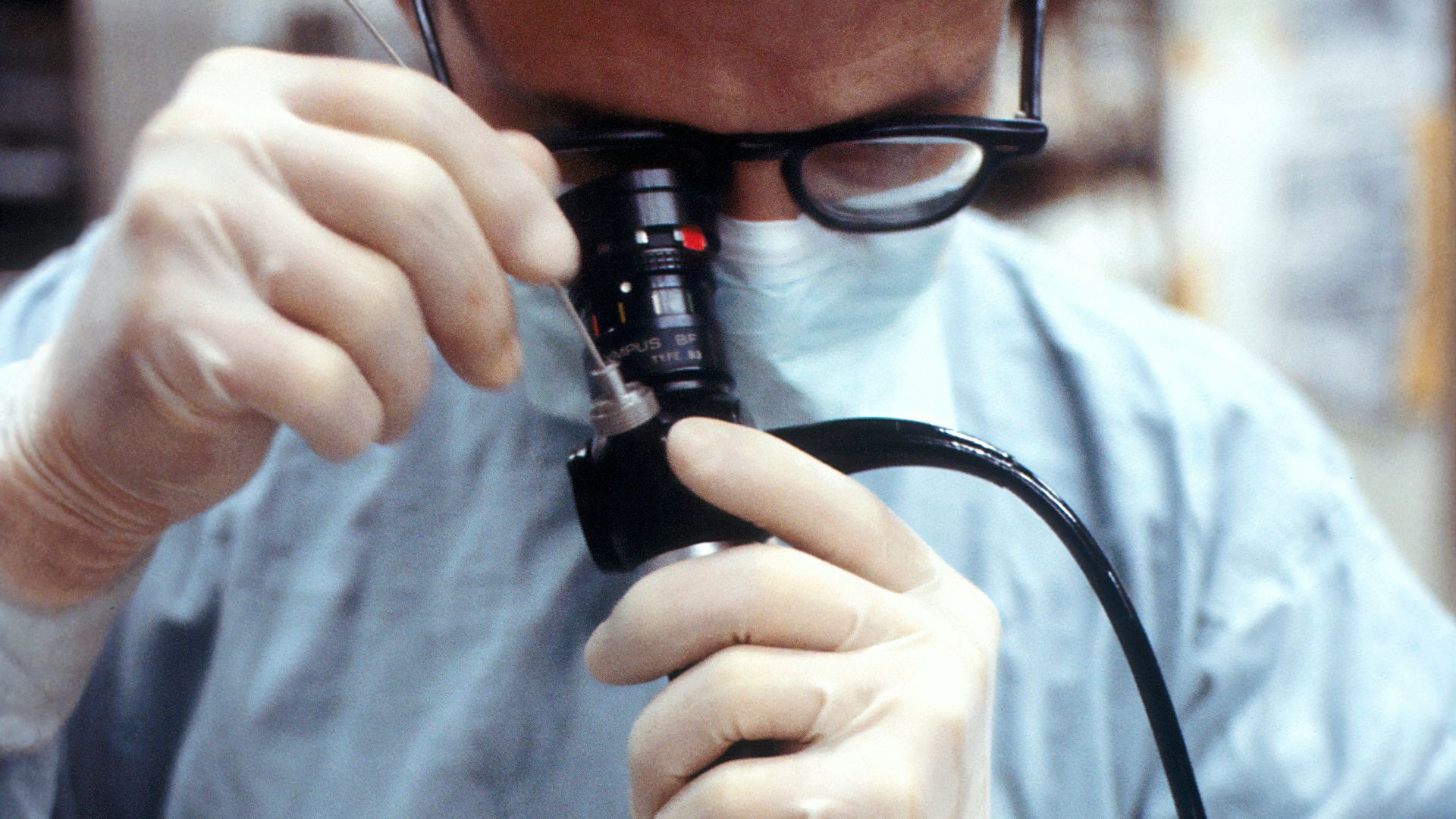 man in blue dress shirt holding black corded device