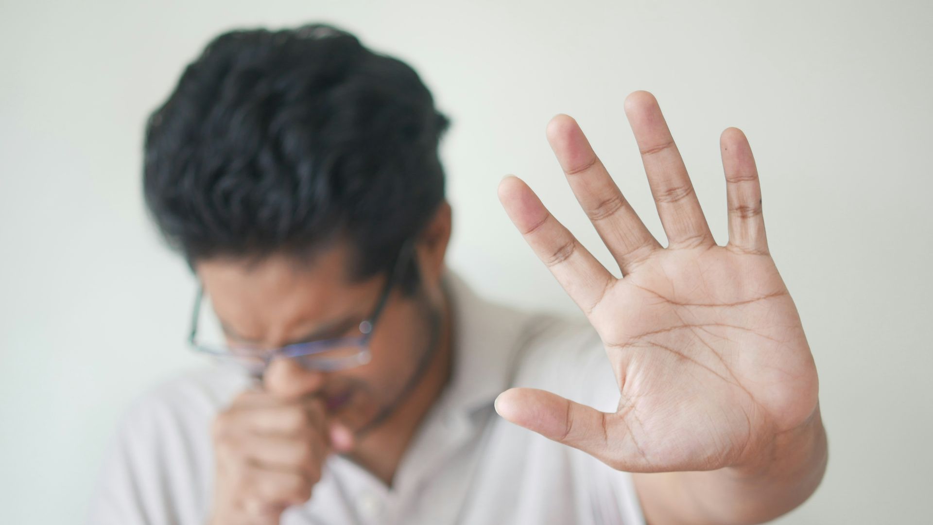 a man holding his hand up in front of his face