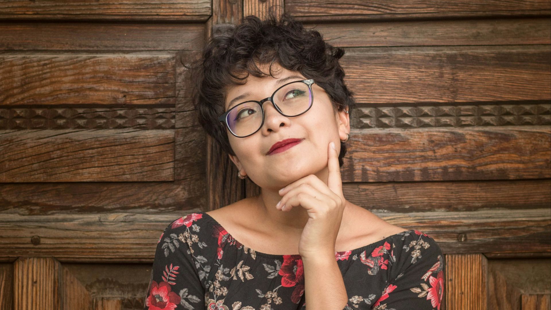 woman leaning against door while holding her cheek