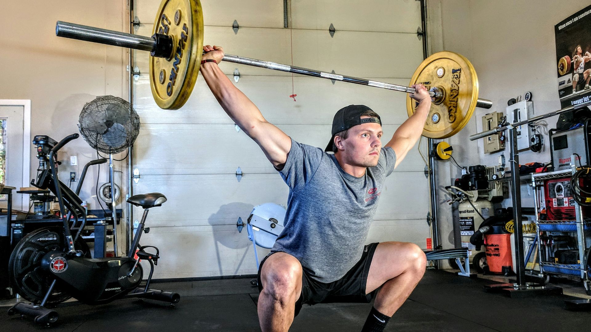 man lifting yellow barbell