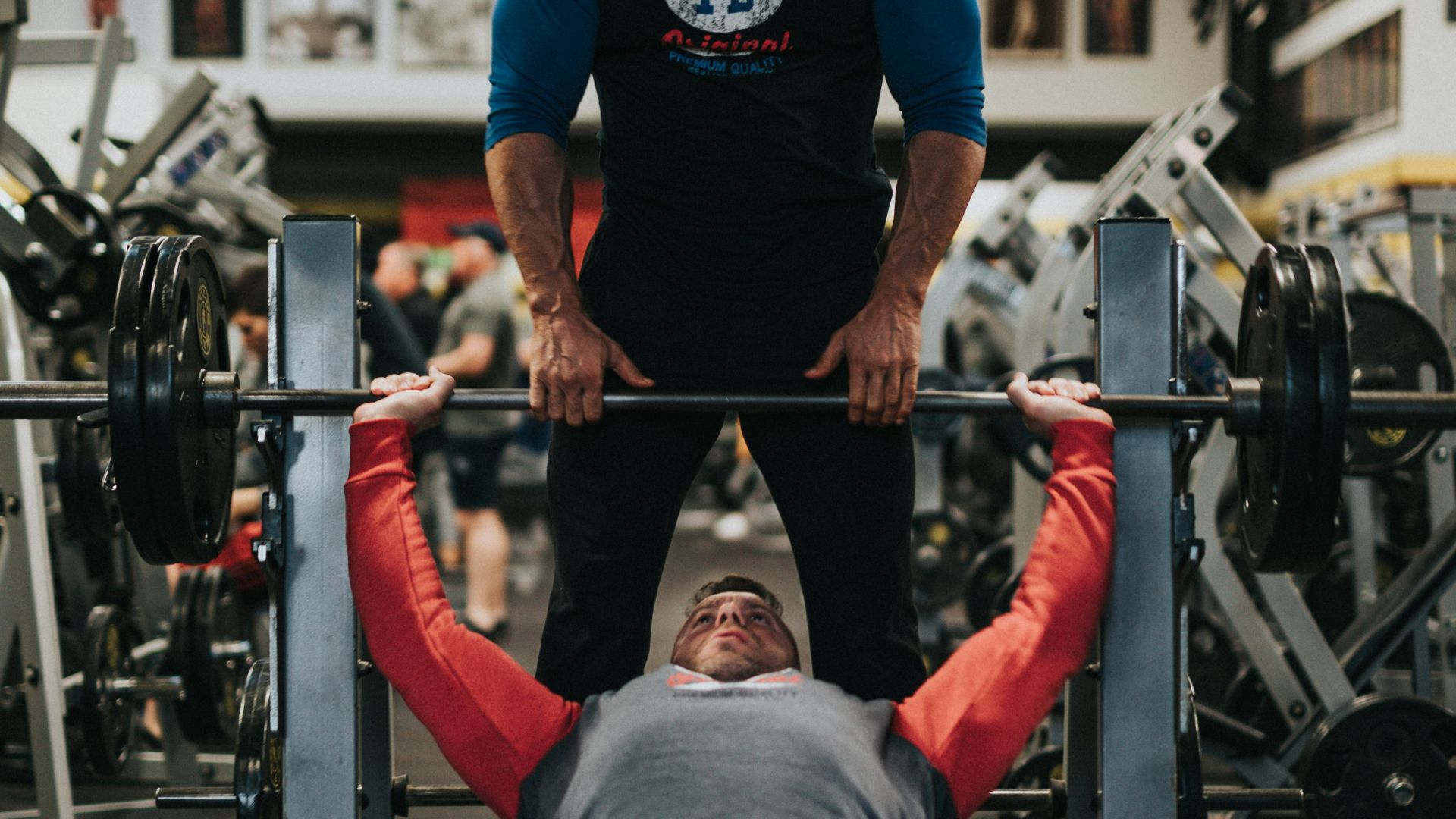 man in black crew neck t-shirt and gray pants sitting on black and red bench