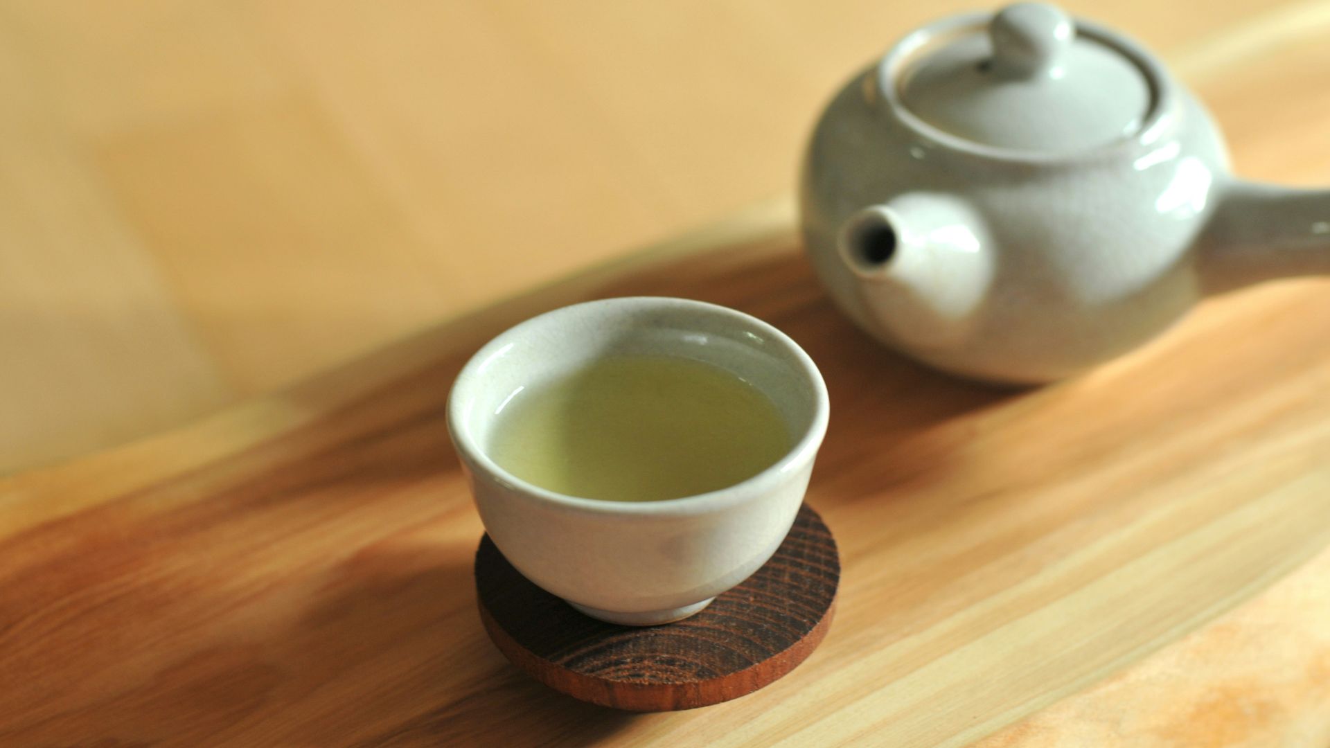 white ceramic teacup on brown wooden table