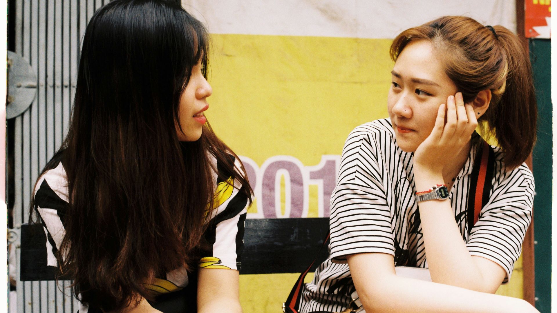 woman in white-and-black striped tops looking each other